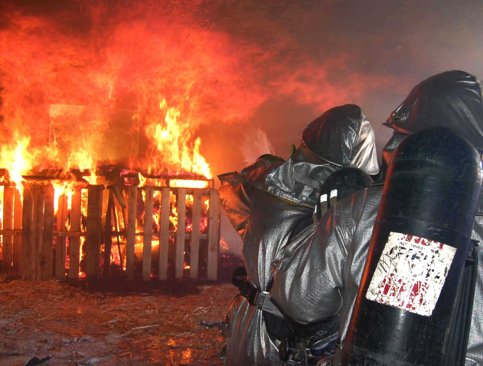 Senior Airmen William Kretsch and Zachary Hedquist work to contain a fire during a live-fire training exercise at Spangdahlem Air Base, Germany, Sept. 10. The Airmen are assigned to the 52nd Civil Engineer Squadron. (U.S. Air Force photo/Staff Sgt. Tammie Moore)
