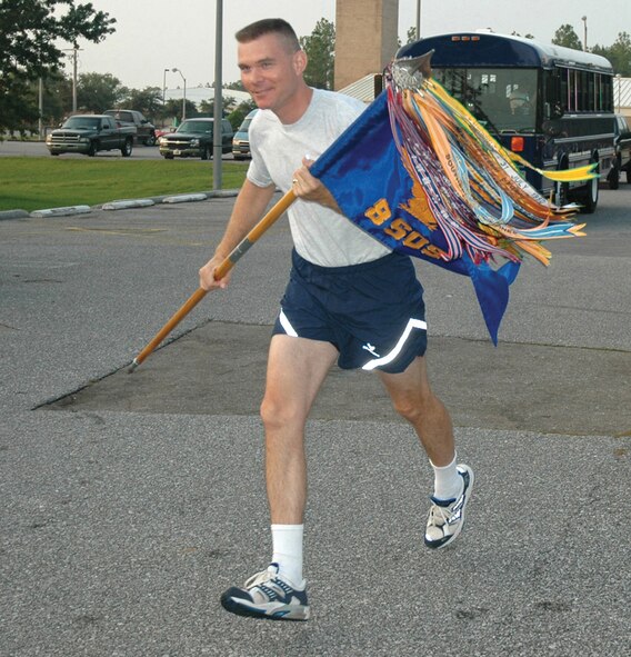 Lt. Col Paul Caltagirone, 8th Special Operations Squadron director of operations, takes his squadron guidon on its first leg of the return journey to its new home at Hurlburt Field Aug. 9. Squadron members took turns carrying the guidon through the 26-mile stretch.