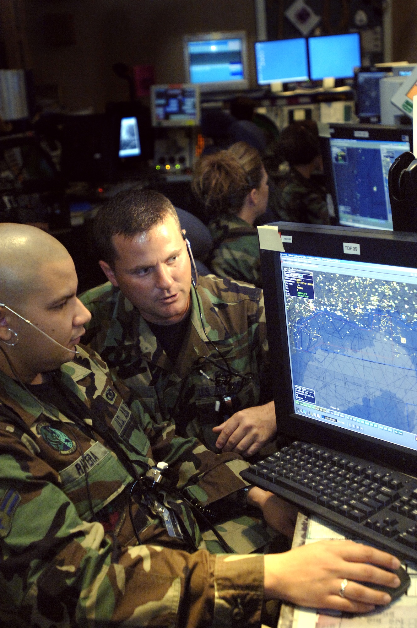 Airman 1st Class Samuel Rivera listens to Master Sgt. Lynn Boop at the Air Operations Center at Tyndall Air Force Base, Fla. Sergeant Boop is superintendent of standards and evaluations for Southeast Air Defense. Airman Rivera is a tracking technician trainee deployed to Southeast Air Defense. (U.S. Air Force photo/Tech. Sgt. Cecilio M. Ricardo Jr.)