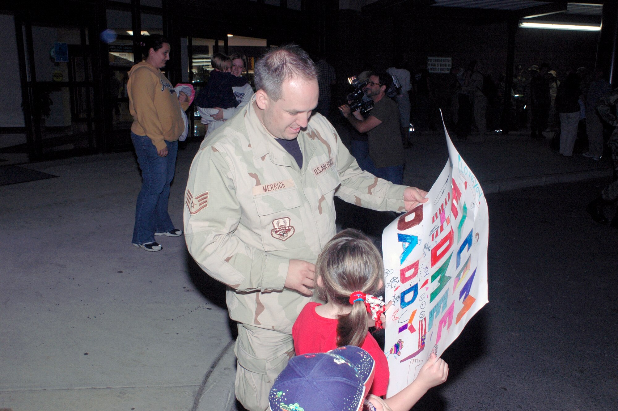 Six-year-old Brienna Merrick, shows off her welcome home sign to her father, Staff Sgt. James Merrick, upon his return to McGuire Air Force Base, N.J., from a deployment to Southwest Asia. Sergeant Merrick is an information controller with the 305th Aerial Port Squadron. (U.S. Air Force photo/Kenn Mann) 

