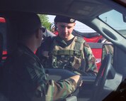 Minot Air Force Base, N.D. -- Airman Eric Syriac, 5th Security Forces Squadron, checks identification cards to ensure only authorized personnel are allowed entry to the base Sept. 11. Checking IDs is a part of support of Antiterrorism during Exercise Prairie Defense.  (U.S. Air Force photo by Airman First Class Joe Rivera) 