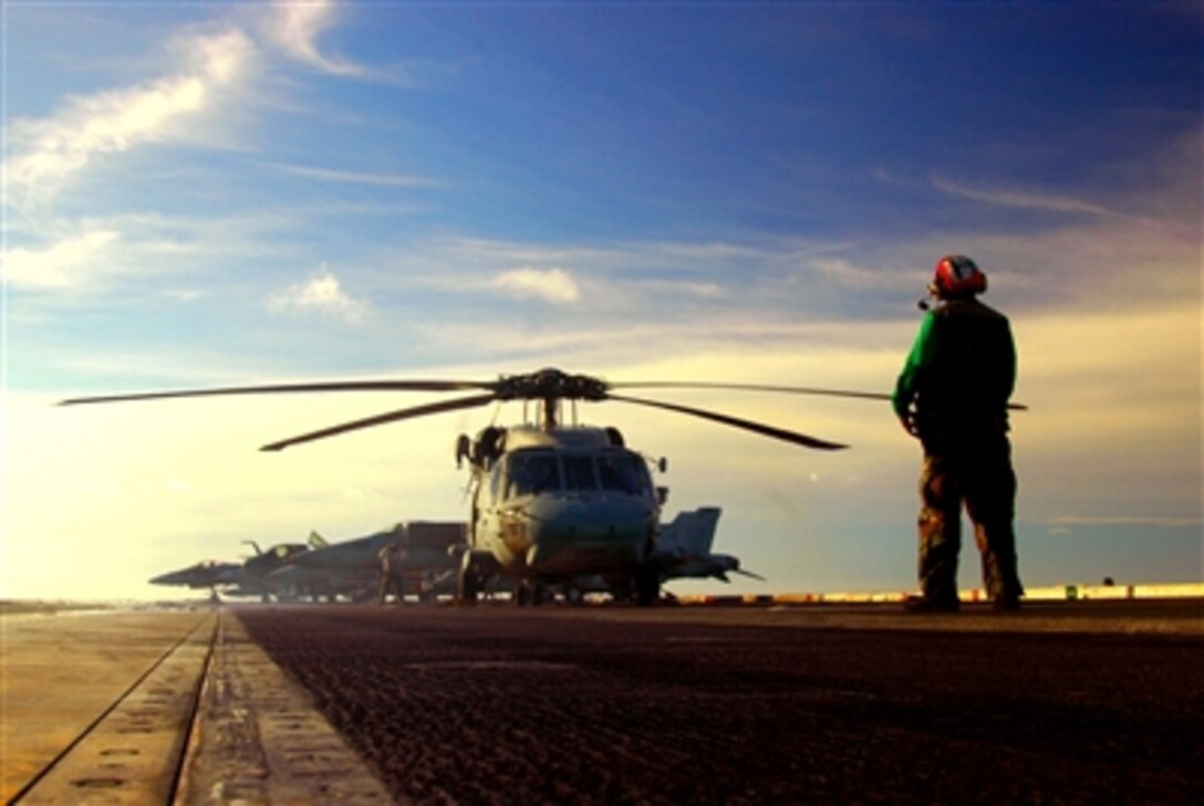 A U.S. Navy sailor from Helicopter Antisubmarine Squadron 14 directs an SH-60H Seahawk helicopter prior to taking off from the flight deck of the USS Kitty Hawk in the Gulf of Thailand, Sept. 6, 2006.  Currently under way in the 7th Fleet area of responsibility, Kitty Hawk demonstrates power projection and sea control as the U.S. Navy's only permanently forward deployed aircraft carrier, operating from Yokosuka, Japan.