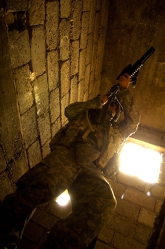 U.S. Army Sgt. Michael Crowley clears the stairway of an abandoned house during a weapons search in Tall Afar, Iraq, on Aug. 27, 2006.  Crowley is assigned to the 2nd Battalion, 37th Armored Regiment, 1st Armored Division, 1st Brigade Combat Team.  