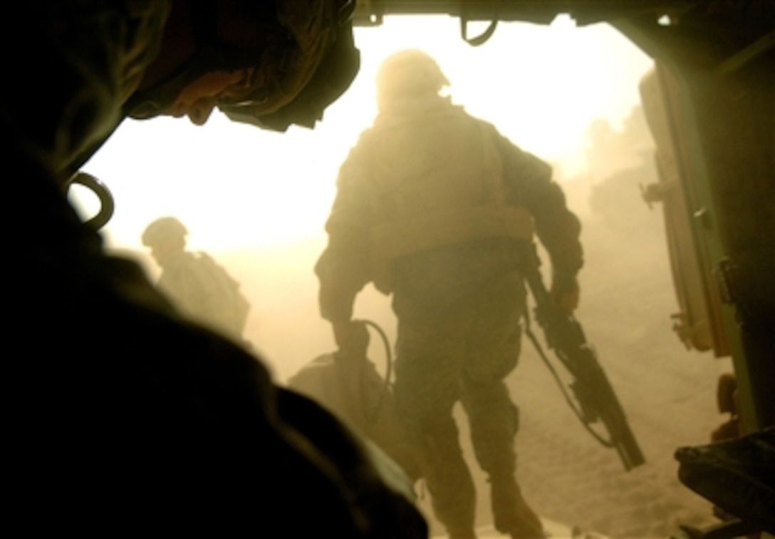 U.S. Army Spc. Jeffery Moore (left) prepares to exit an M 2 Bradley fighting vehicle at Camp Ar Ramadi, Iraq, following a raid in the Tameem district of Ramadi, Iraq, on Sept. 3, 2006.  Moore is assigned to Bravo Company, 2nd Battalion, 6th Infantry Regiment, 1st Armored Division.  