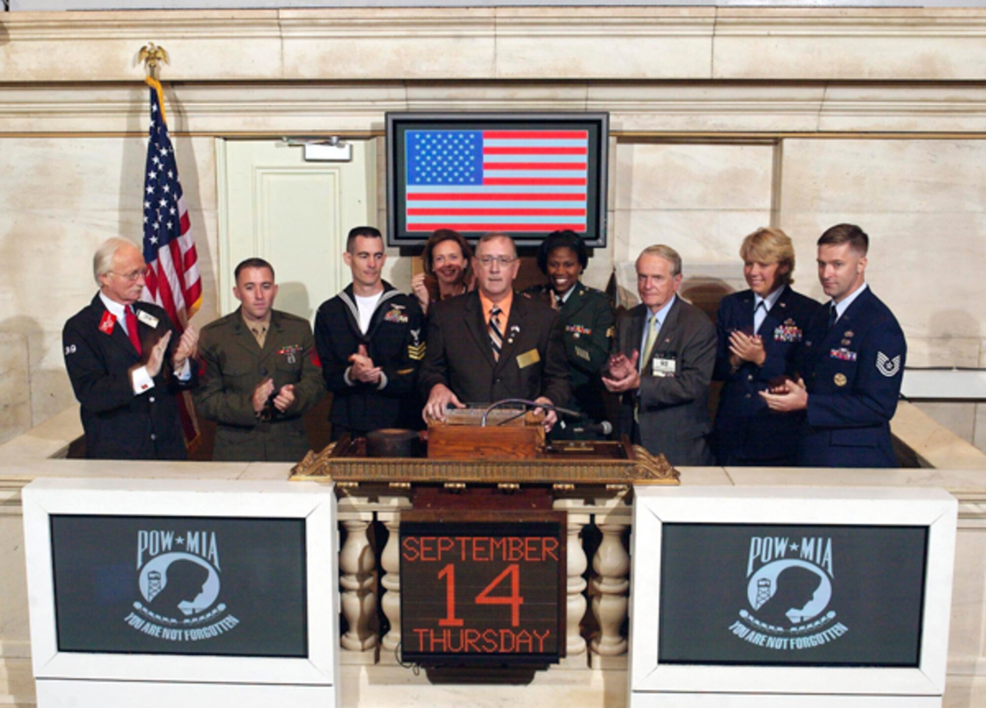 William Frampton (center), senior liaison officer with the U.S. Air Force Missing Persons Branch, rings the closing bell at the New York Stock Exchange on Sept. 14. With Mr. Frampton are (left to right) John Erik Smith, exchange sergeant at arms; Marine Cpl. Robert Beck; Petty Officer 1st Class Darren Rodriguez; Catherine Kinney, president and co-chief operating officer for the exchange; Army Sgt. Melanie Moore; James McGuire, an exchange trader and a Korean War veteran; Master Sgt. Susan Williams; and Tech. Sgt. Stephen Wilson. The servicemembers visited the exchange to commemorate National POW/MIA Recognition Day by being present at the ringing the closing bell.   (Photo courtesy of NYSE)
