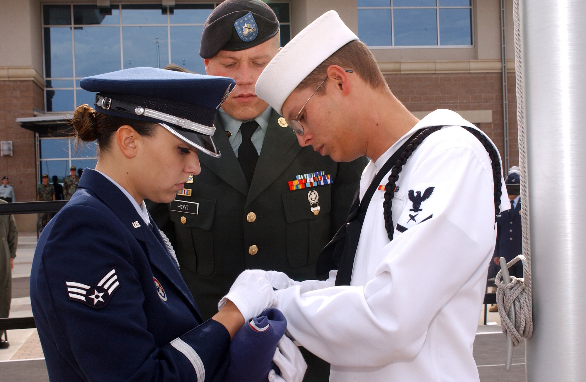 BUCKLEY AIR FORCE BASE, Colo. -- Senior Airman Jaclyn Chateau, 460th Medical Group, Army Specialist Jon Hoyt, 743rd Military Intelligence Battalion, and Petty Officer 3rd Class Spencer Turner, Naval Information Operations Command, fold the flag during the 460th Space Wing's Patriot Day retreat ceremony Monday to honor the 9/11 victims and those who've fallen to ensure an attack like that never happens again.  (U.S. Air Force Photo by Airman 1st Class Logan Tuttle)