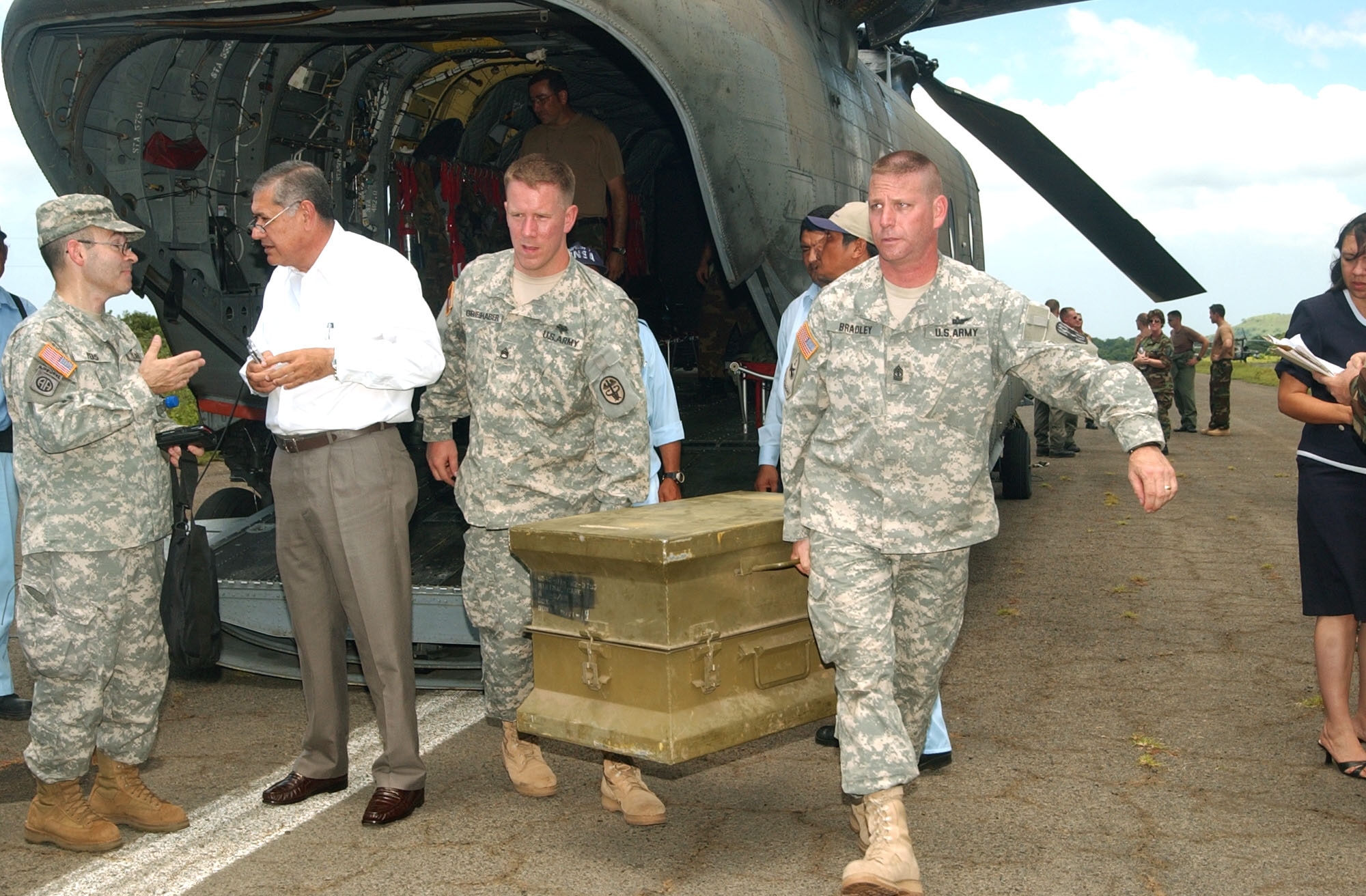 Army Staff Sgt. William Grieshaber and Army Master Sgt. John Bradley remove a trunk with medical equipment from a Chinook helicopter in Leon, Nicragua, Sept. 13 while Army Lt. Col. Robert Pero talks with Israel Konturosky, the sub minister of health to Nicaragua. Members from Joint Task Force-Bravo at Soto Cano Air Base, Honduras, responded to a request for help from the U.S. Embassy in Nicaragua when a hospital became overwhelmed with people who had been poisoned by a toxic batch of moonshine. (U.S. Air Force photo/Capt. Alysia Harvey)
