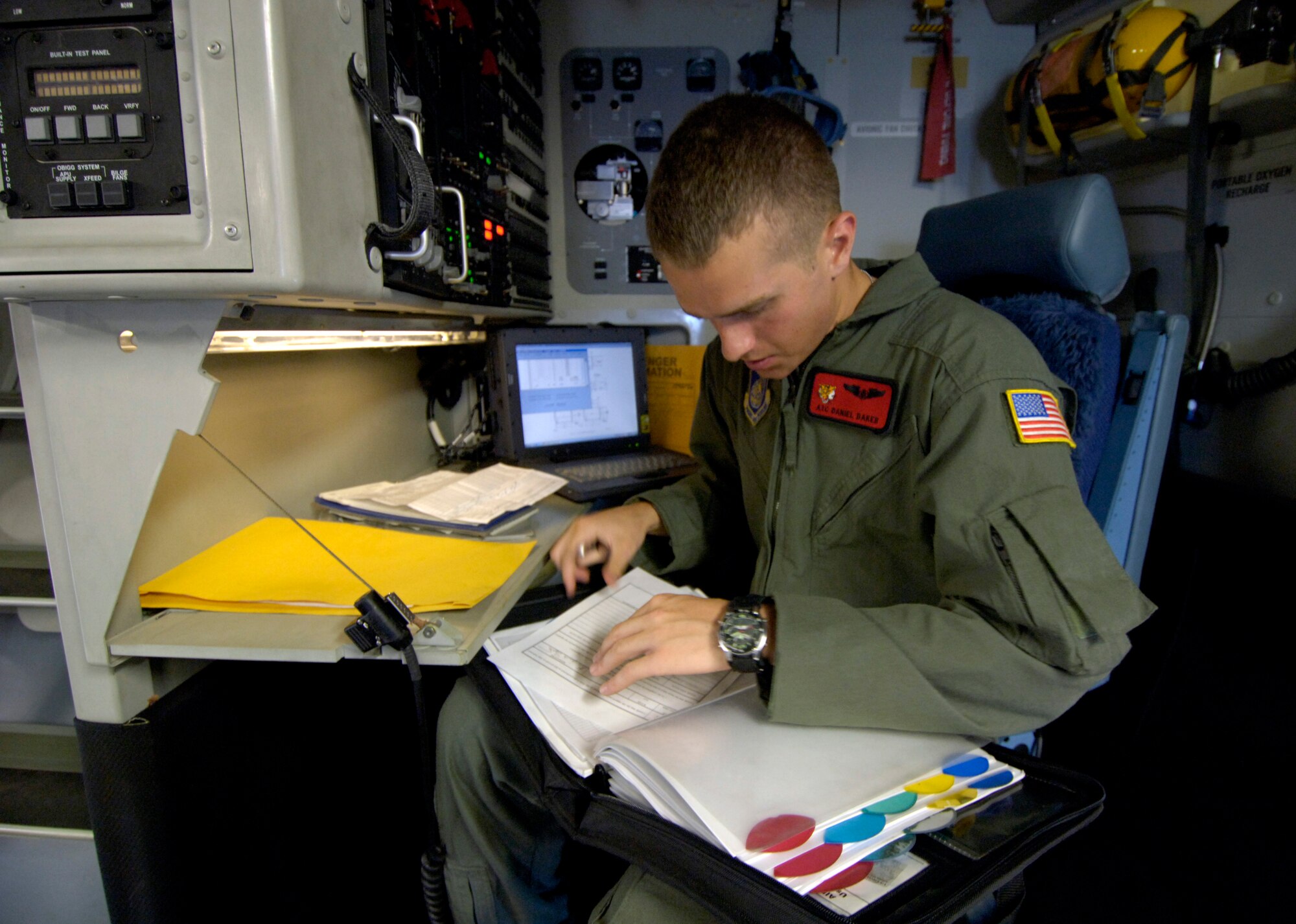 Airman First Class Daniel Baker looks over aircraft forms prior to taking off on a mission from Hickam Air Force Base, Hawaii Sept. 12, 2006. A1C Baker is a C-17 Globemaster III loadmaster from the 535th Airlift Squadron. The C-17 is taking a 53-person team comprised of CE, Defense Department employees and contractors to assess damage left by Super Typhoon Ioke after it struck Wake Island Aug. 31. (U.S. Air Force photo/ Tech. Sgt. Shane A. Cuomo)