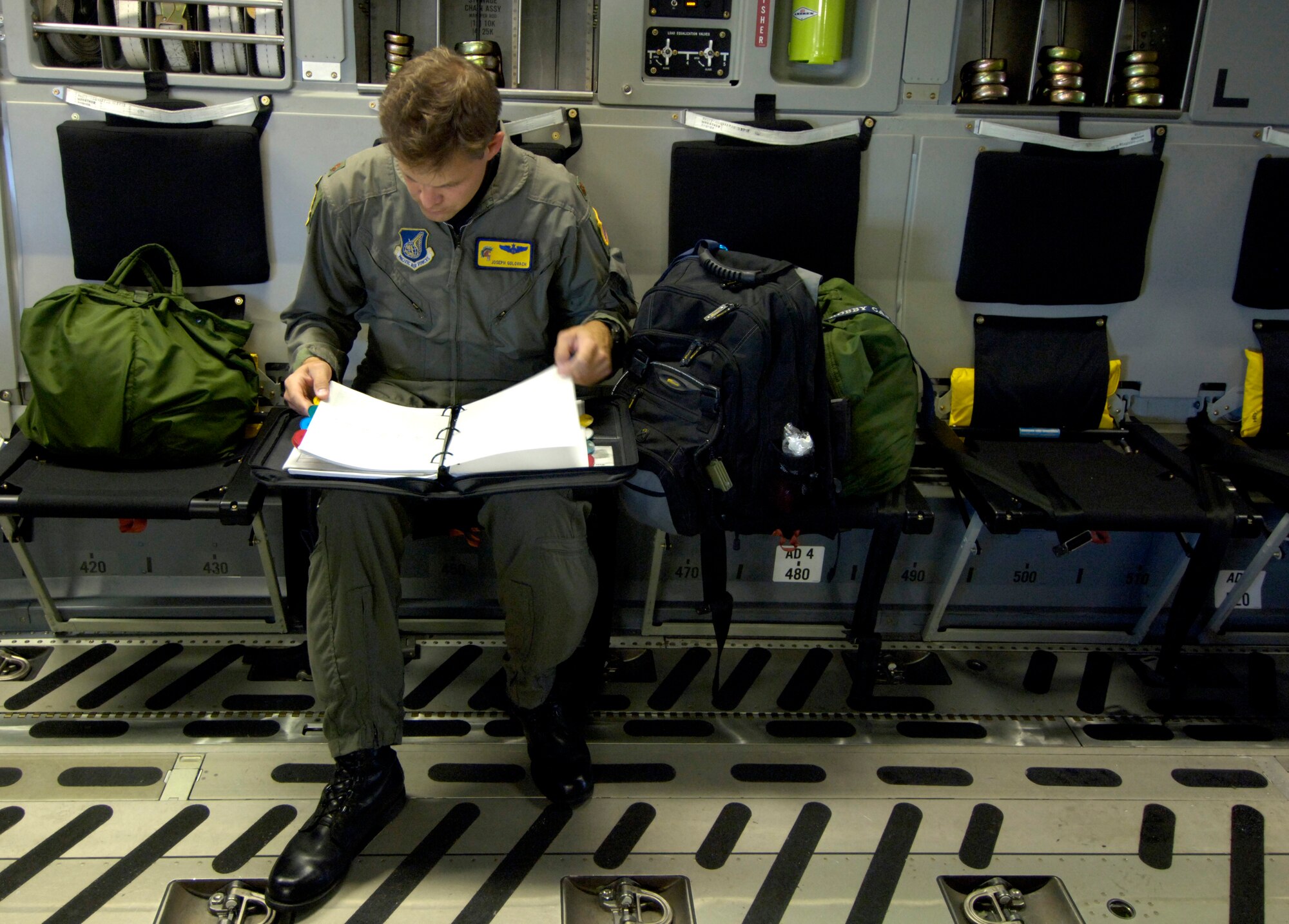 Maj. Joseph Golovach looks over his C-17 Globemaster III aircraft forms prior to taking off on a mission from Hickam Air Force Base, Hawaii Sept. 12, 2006. Maj. Golovach is the C-17 aircraft commander from the 535th Airlift Squadron who is flying a 53-person team comprised of CE, Defense Department employees and contractors to assess damage left by Super Typhoon Ioke after it struck Wake Island Aug. 31. (U.S. Air Force photo/ Tech. Sgt. Shane A. Cuomo)
