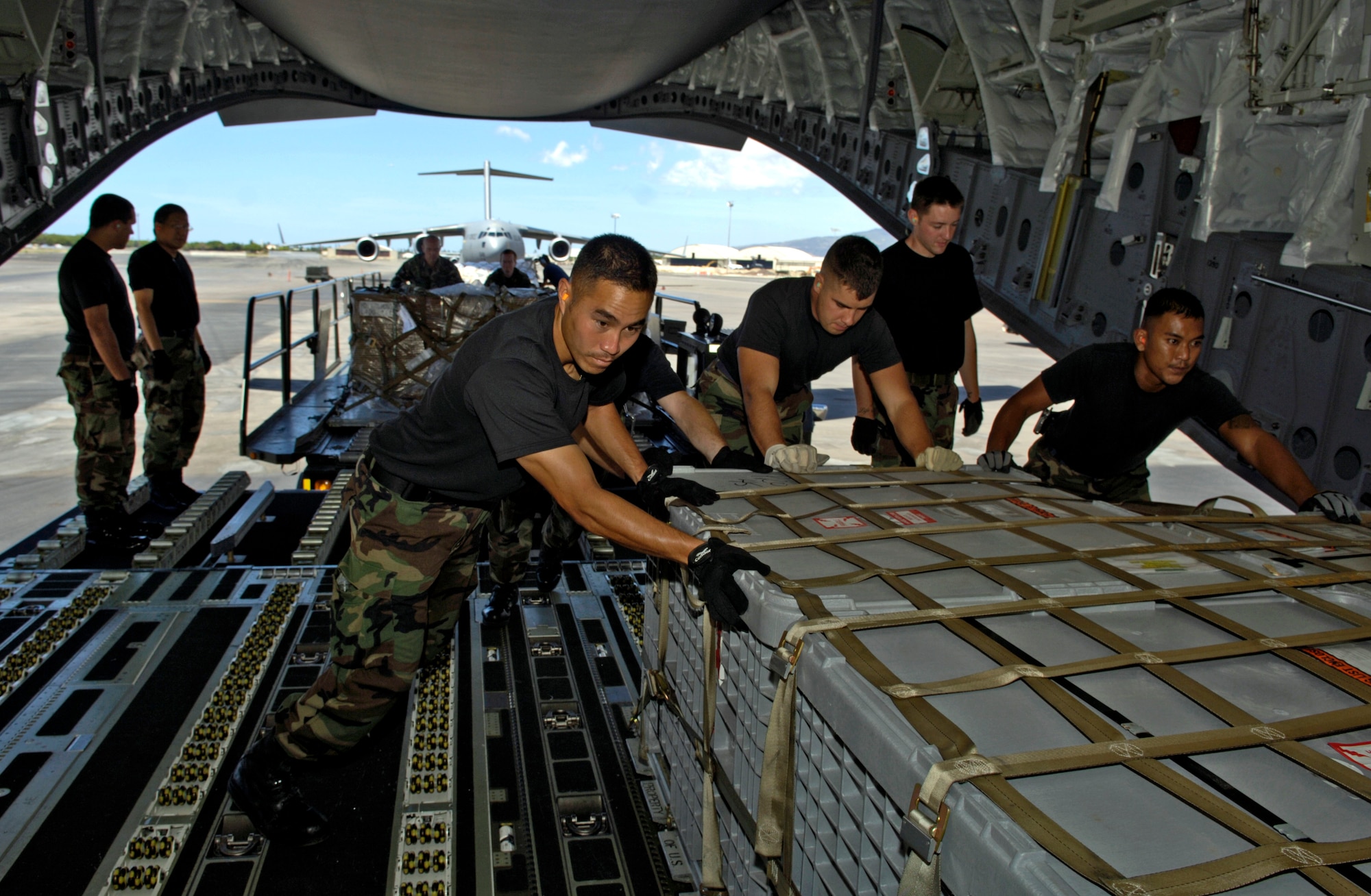 Members from the 15th Civil Engineering Squadron load pallets of equipment on a C-17 Globemaster III at Hickam Air Force Base Hawaii Sept. 12, 2006. The C-17 is taking a 53-person team comprised of CE, Defense Department employees and contractors to assess damage left by Super Typhoon Ioke after it struck Wake Island Aug. 31. (U.S. Air Force photo/ Tech. Sgt. Shane A. Cuomo)