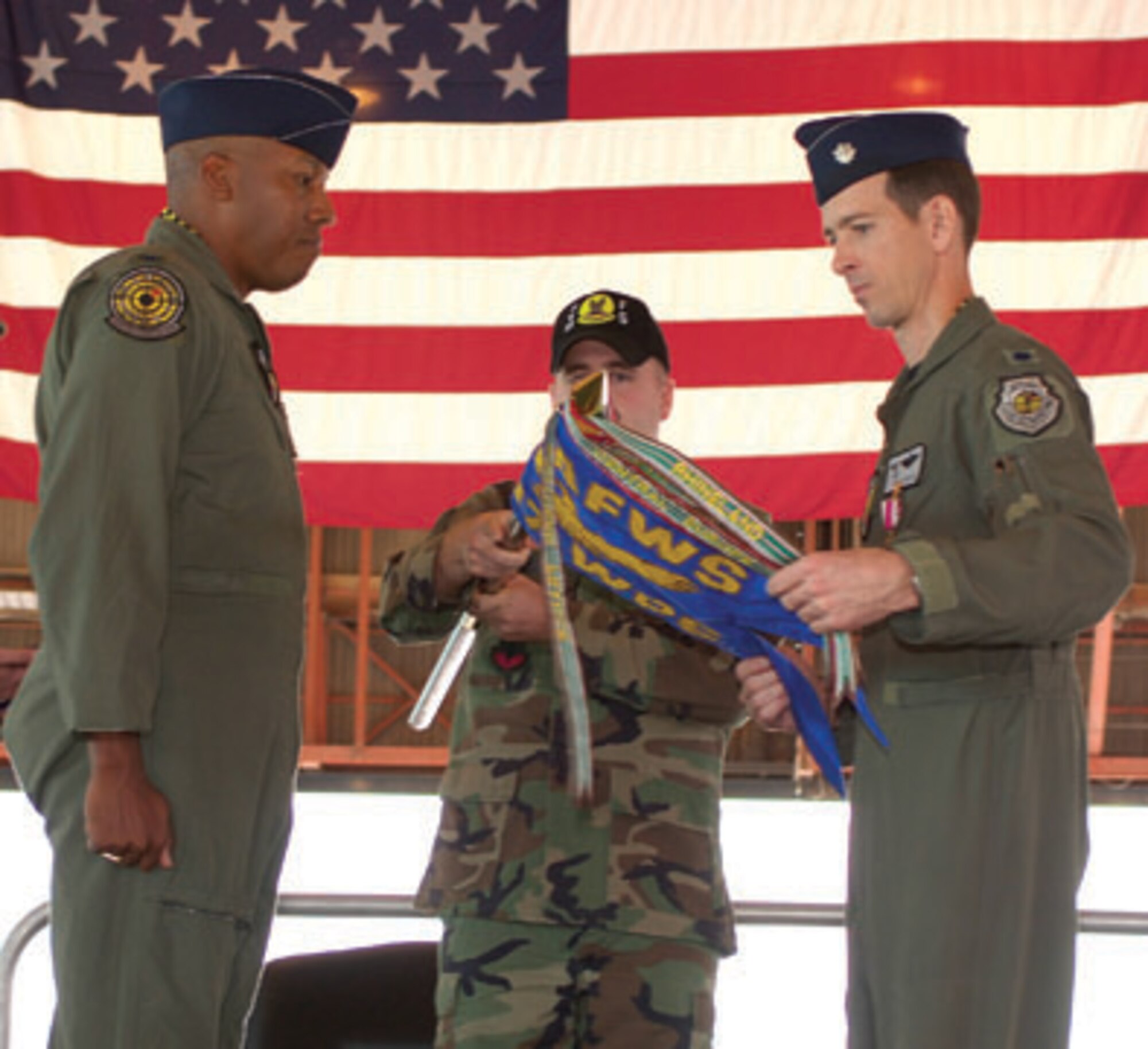 Col. C.Q. Brown Jr., U.S. Air Force Weapons School ommandant, watches as Lt. Col. Marc Reese, 417th Weapons Squadron commander wraps up the squadron guidon during the inactivation ceremony Friday.