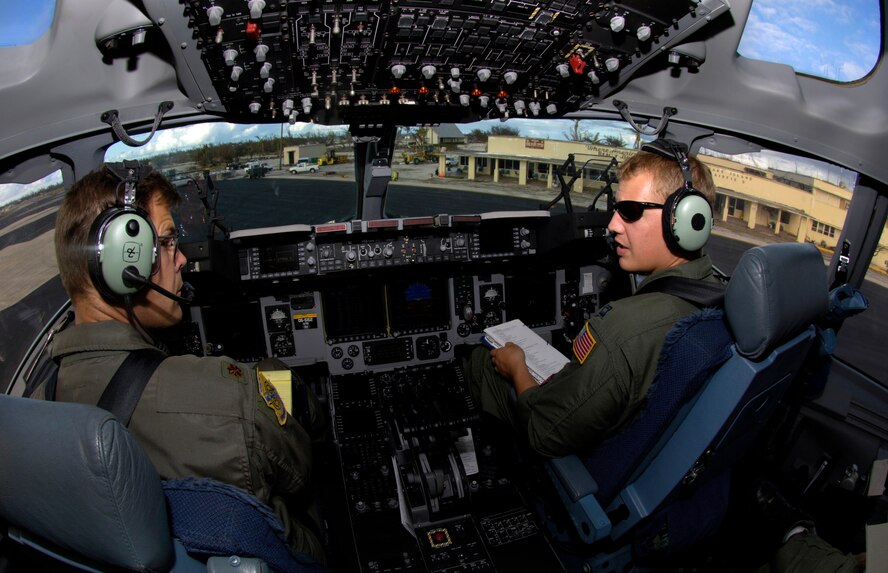Maj. Joseph Golovach and Capt. John Ramsey III prepare to leave Wake Island in their C-17 Globemaster III Sept. 12 2006. The C-17 is taking the 36th Contingency Response Group from Andersen Air Force Base, Guam back home. The 36th CRG was the initial assessment team on the island to survey the airfield and determine if aircraft could land after the island was hit by Super Typhoon Ioke Aug 31. The pilots are from the 535th Airlift Squadron, Hickam Air Force Base, Hawaii. (U.S. Air Force photo/ Tech. Sgt. Shane A. Cuomo)