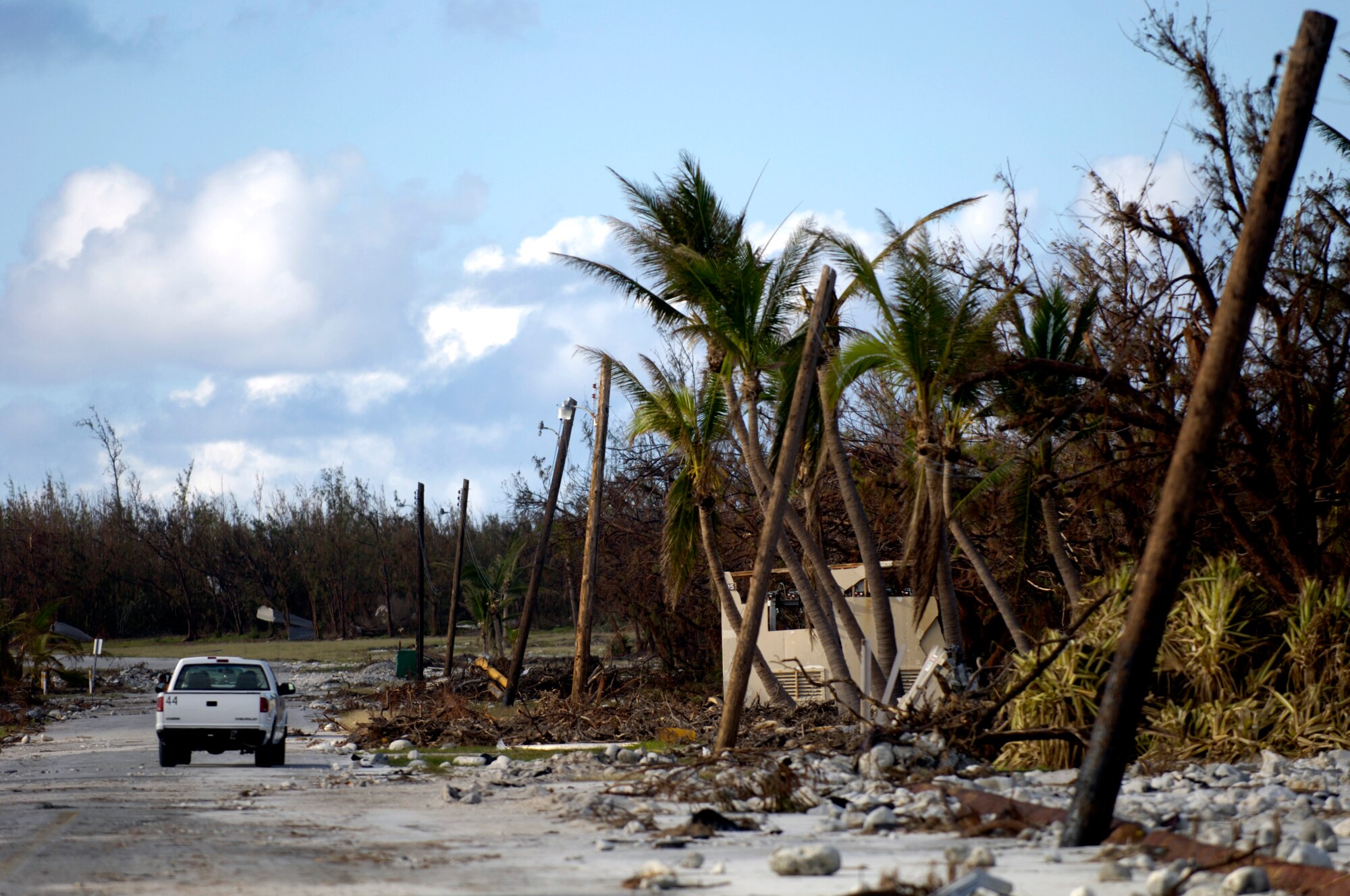 A truck drives past the devastation left by Super Typhoon Ioke on Wake Island Sept. 12. A C-17 Globemaster III from the 535th Airlift Squadron at Hickam Air Force Base, Hawaii, brought a 53-person team to assess damage left by the typhoon after it struck the island Aug. 31. (U.S. Air Force photo/Tech. Sgt. Shane A. Cuomo) 

