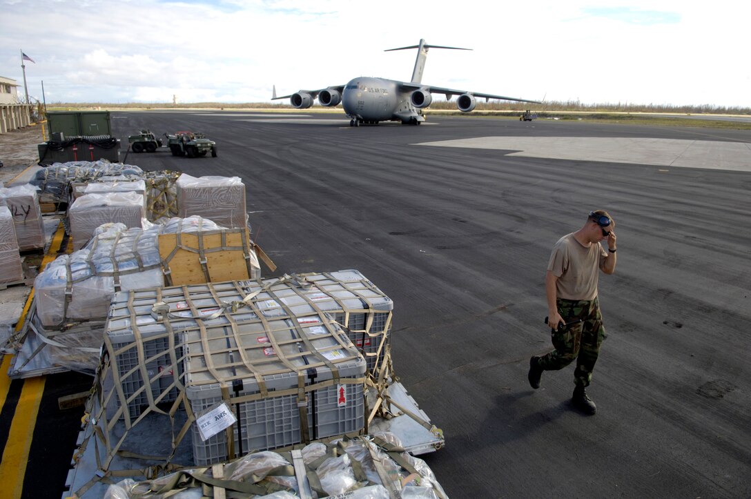 Tech. Sgt. Timothy Galunas lines up pallets on the Wake Island flightline Sept. 12, after they were offloaded from the C-17 Globemaster III in the background. Sergeant Galunas is with the 36th Contingency Response Group at Andersen Air Force Base, Guam. They are assisting a 53-person team assessing damage left by Super Typhoon Ioke after it hit the island Aug. 31. (U.S. Air Force photo/Tech. Sgt. Shane A. Cuomo) 