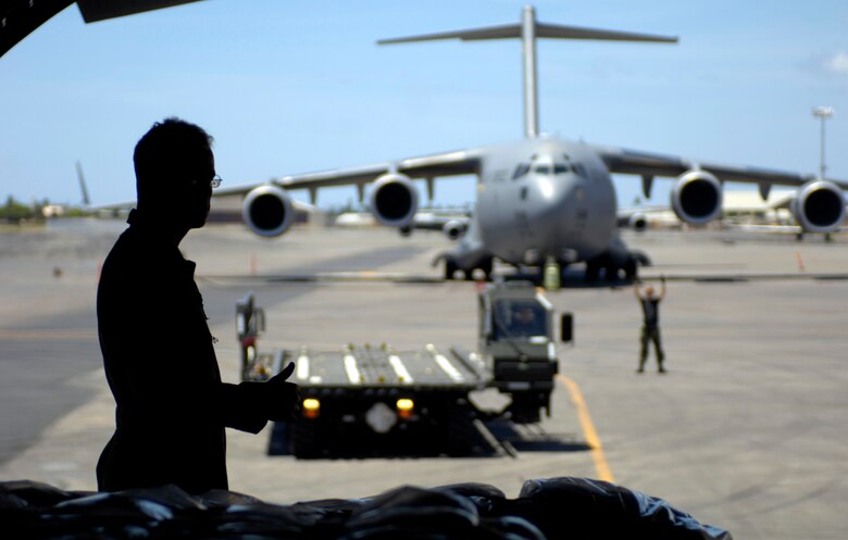 Airman 1st Class Charles Gibb gives a thumbs up after completing a cargo upload at Hickam Air Force Base, Hawaii, Sept. 12. Airman Gibb is a C-17 Globemaster III loadmaster from the 535th Airlift Squadron. The C-17 took a 53-person team comprised of civil engineers, Defense Department employees and contractors to assess damage left by Super Typhoon Ioke after it struck Wake Island Aug. 31. (U.S. Air Force photo/Tech. Sgt. Shane A. Cuomo) 
