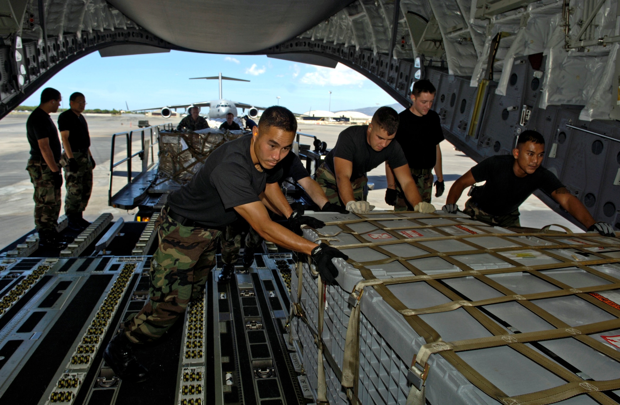 Airmen from the 15th Civil Engineer Squadron load pallets of equipment on a C-17 Globemaster III at Hickam Air Force Base, Hawaii, Sept. 12. The C-17 took a 53-person team comprised of CE, Defense Department employees and contractors to assess damage left by Super Typhoon Ioke after it struck Wake Island Aug. 31. (U.S. Air Force photo/Tech. Sgt. Shane A. Cuomo) 