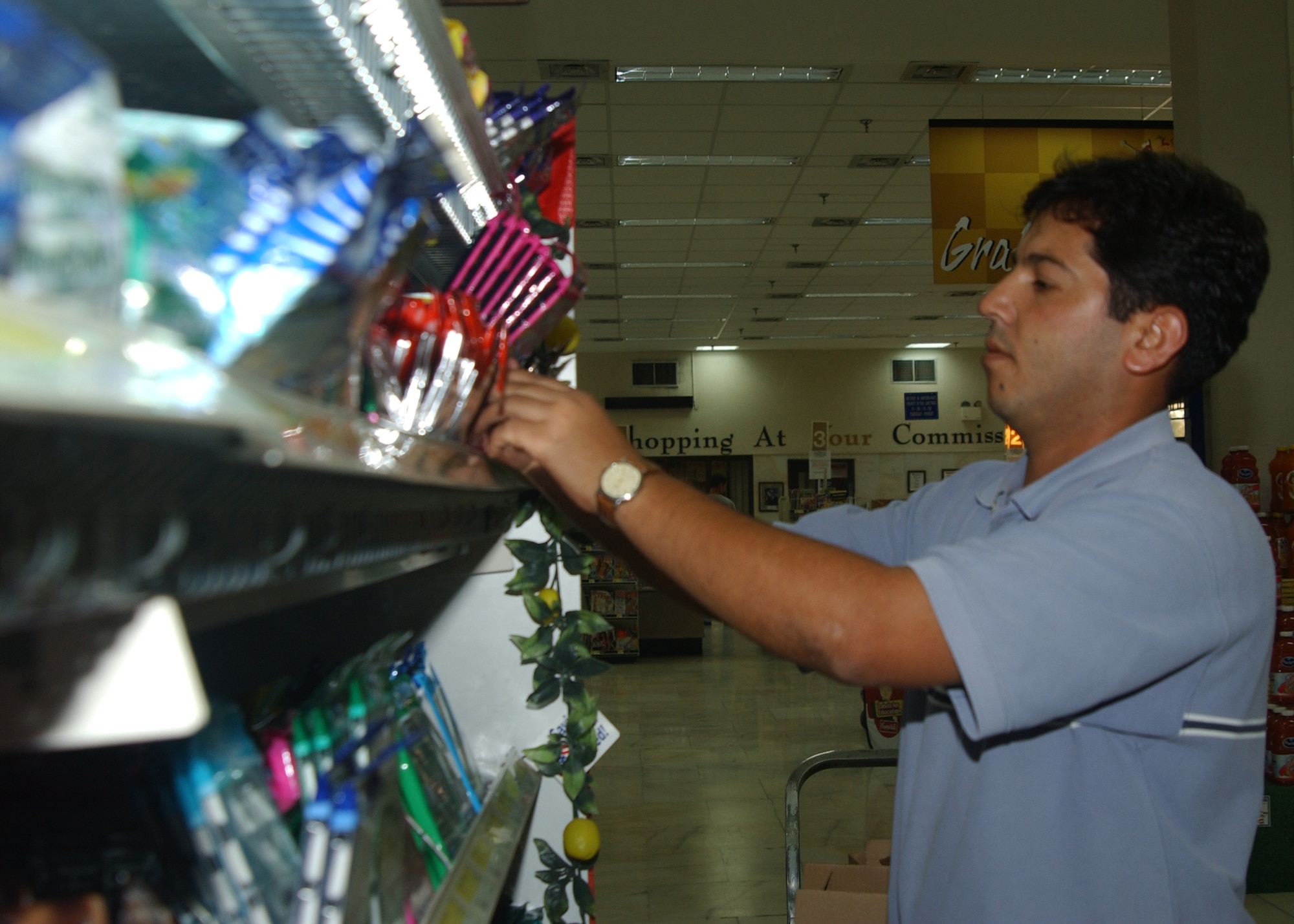 Mahmut Jilmal, DECA employee,  stocks food at the commissary here Thursday.(U.S.Air Force photo by Airman Kelly LeGuillon)