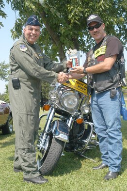GRISSOM AIR RESERVE BASE, Ind -- Brig. Gen. Dean J. Despinoy, 434th Air Refueling Wing commander, presents Tech. Sgt. James Coyle a trophy for the commander's choice motorcycle award at the wheel show during the joint family day picnic. (U.S. Air Force photo/SrA Roberto Modelo)