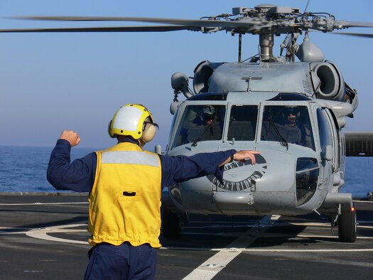A crewmember marshalls Ghostrider, the CH-60 helicopter assigned to USS Mount Whitney (LCC-20) to transfer personnel to the USS Wasp (LHD-1) for Joint Task Force Lebanon in the Mediterranean Sept. 6. Photo by Maj. Lisa Neidinger.
