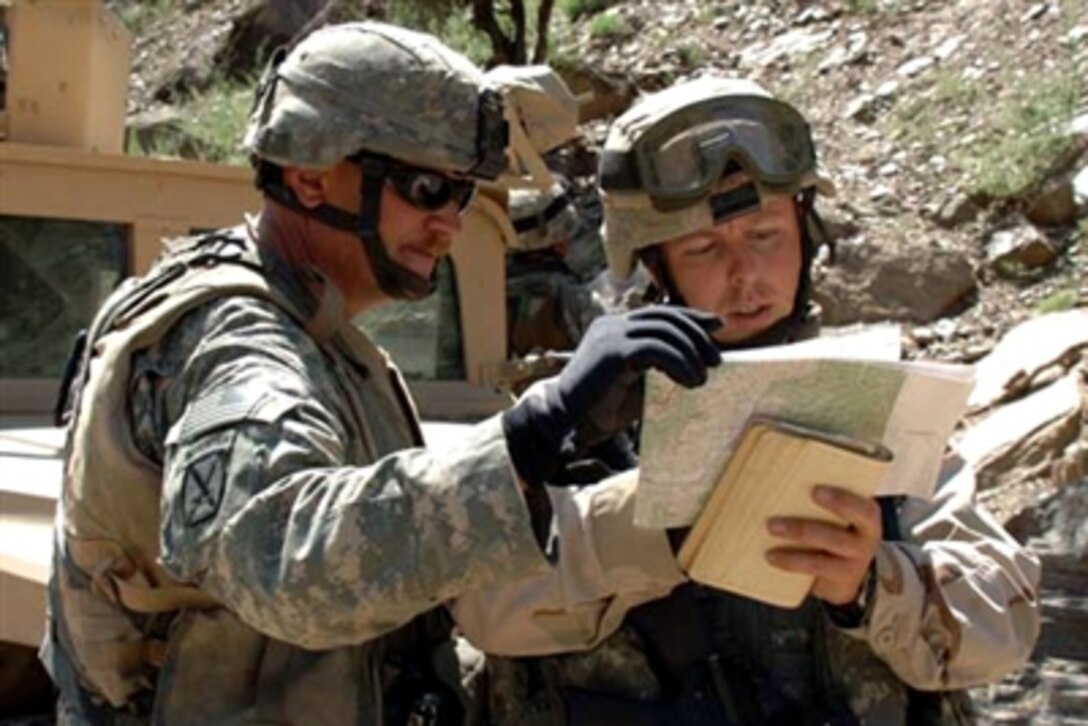 U.S. Army Maj. Nord, left, and U.S. Navy Lt. j.g. Hayes, Asadabad Provincial Reconstruction Team, 10th Mountain Division, plot coordinates for a section of road to be inspected in the Nuristan province of Afghanistan, Sept. 3, 2006.