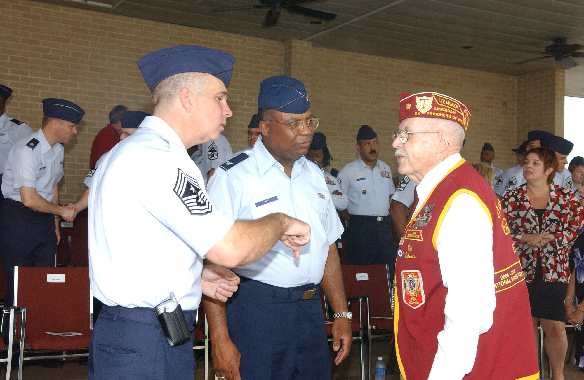 Chief Master Sgt. Dwayne Hopkins and Col. Stevenson Ray chat with retired Maj. Bill Roberts during the 37th Training Wing basic training graduation parade Sept. 15 at Lackland Air Force Base, Texas.  The parade recognized POW/MIA Day.  Major Roberts was a World War II POW after his B-17 Flying Fortress was shot down over Czechoslovakia.  Chief Hopkins is the 37th TRW command chief and Colonel Ray is the wings director of staff.  (U.S. Air Force photo/Alan Boedeker) 