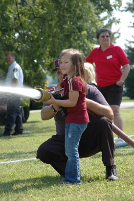 GRISSOM AIR RESERVE BASE, Ind -- A young girl sprays a target set up by the Grissom Fire Department during the joint family day picnic. Families from Air Force Reserve, Army Reserve, Navy Reserve and Marine Corps Reserve units at Grissom, along with military retirees, came together for a fun and educational day.  (U.S. Air Force photo/SrA. Ben Mota)