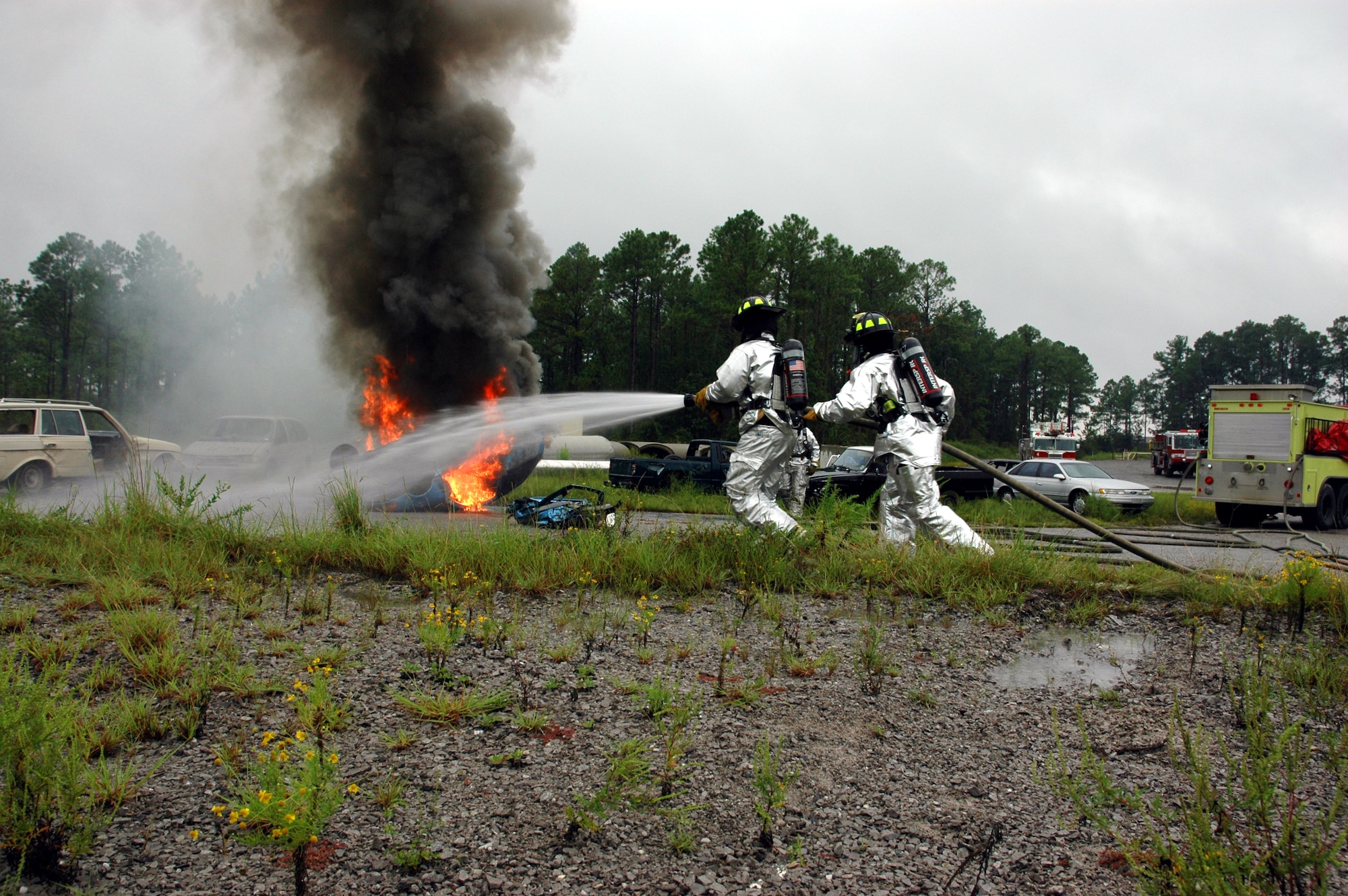 Two Hurlburt Field firefighters run toward a vehicle fire during a training session with Okaloosa Island, Ocean City-Wright and Valparaiso fire departments Monday. The departments work together regularly off-base help to coordinate the flow of manpower when at an accident scene or fire. (U.S. Air Force Photograph by Jamie Haig)

