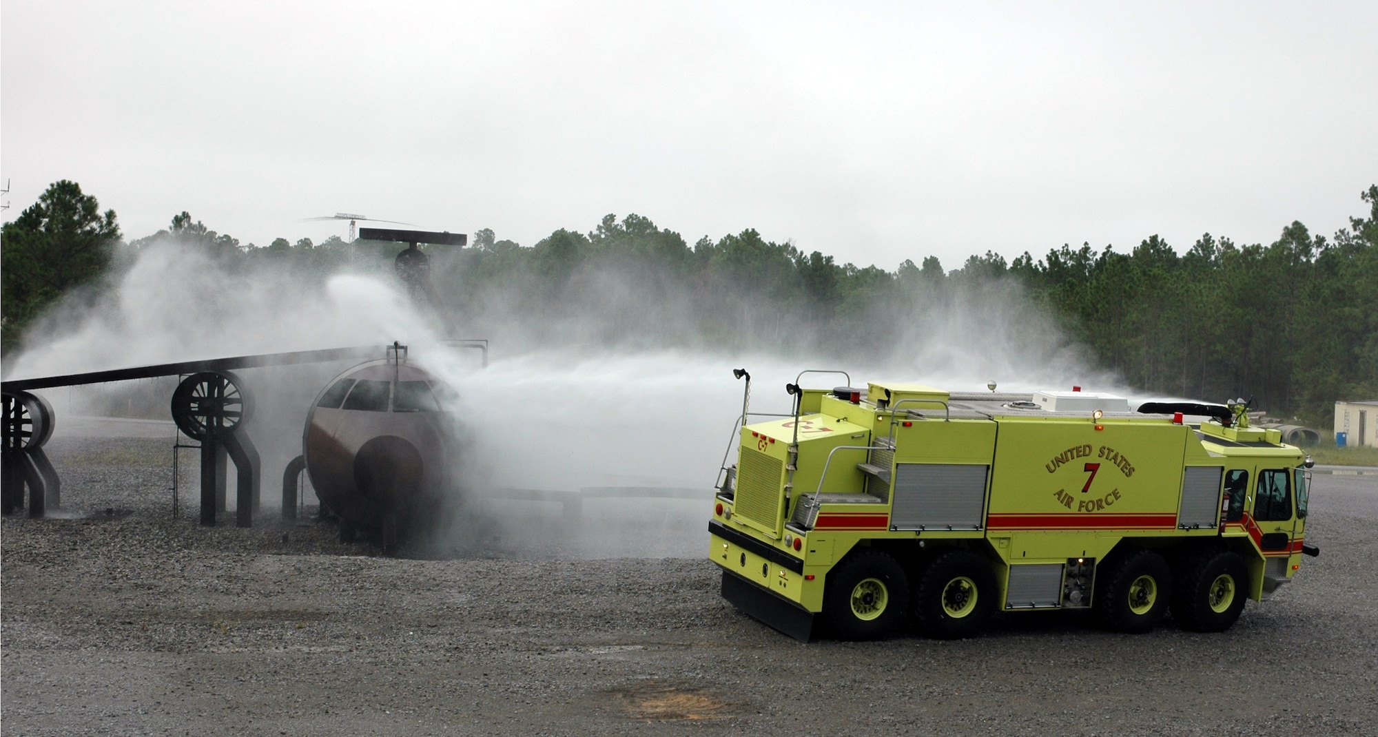 A Hurlburt Field crash fire truck tests its hoses on an aircraft shell used for training. The vehicle circles the aircraft, discharging 300 gallons of water within a matter of minutes.
(U.S. Air Force Photograph by Jamie Haig)

