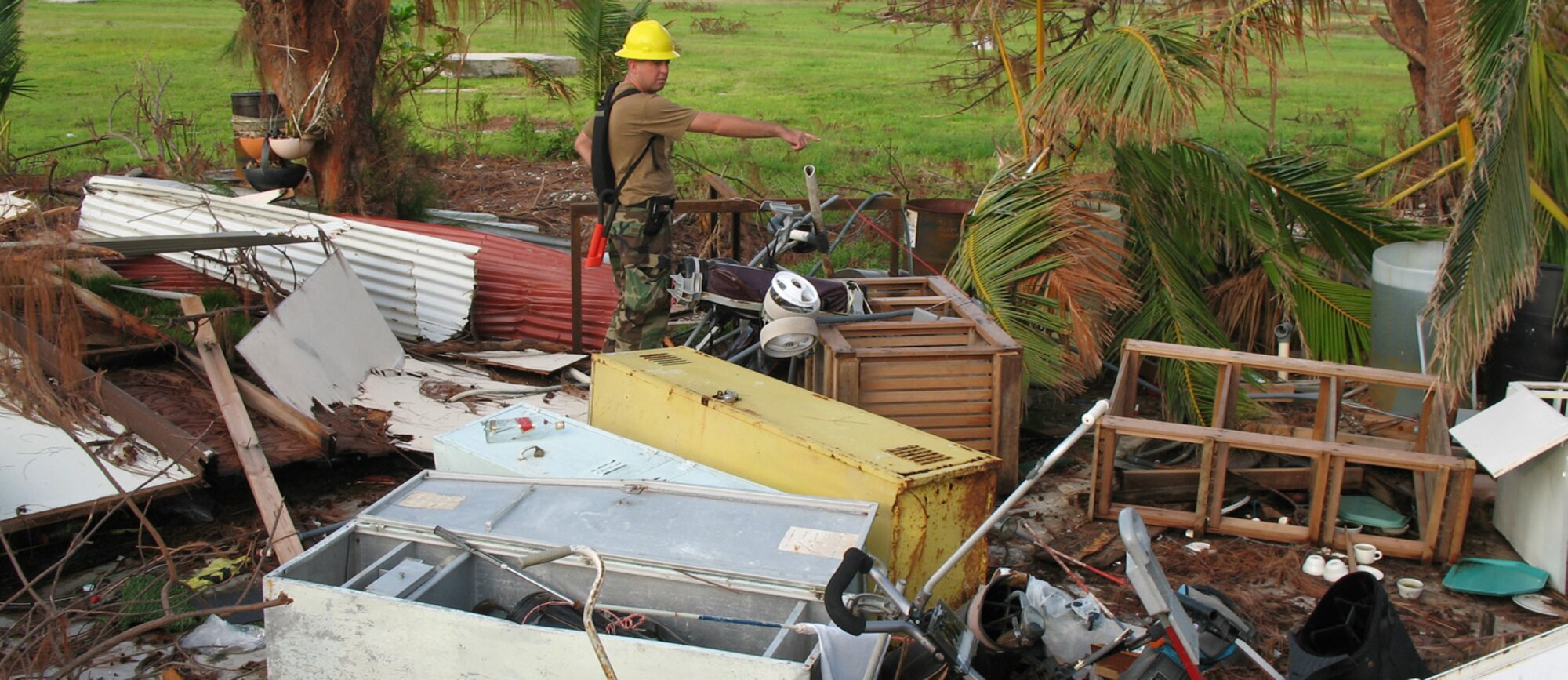 Tech. Sgt. Dennis Tye points out things of note to other members of the 15th AIrlift Wing's Damage Assessment Team on Sept 15, 2006. The team was sent to estimate the cost of damage left by Super Typhoon Ioke, which swept through the atoll on Aug 31. All the team knows about this area is that it used to be Building 2100, and that it appears to have been a storage area, perhaps for the golf course. (U.S. Air Force photo / Tech. Sgt. Chris Vadnais)