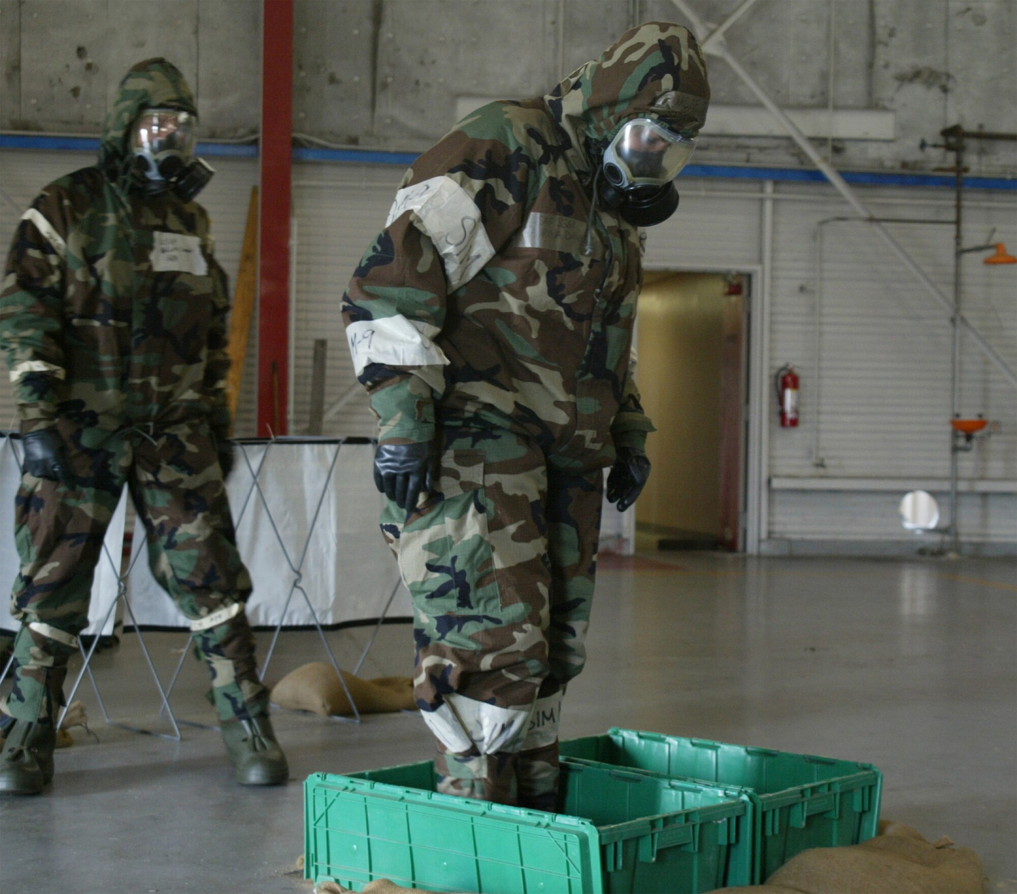 Staff Sgt. Sabrina Davis decontaminates her boots by shuffling through bleach and water. This was simulated as part of the Ability to Survive and Operate Exercise. (U.S. Air Force photo/Tech. Sgt. Vicki Johnson)