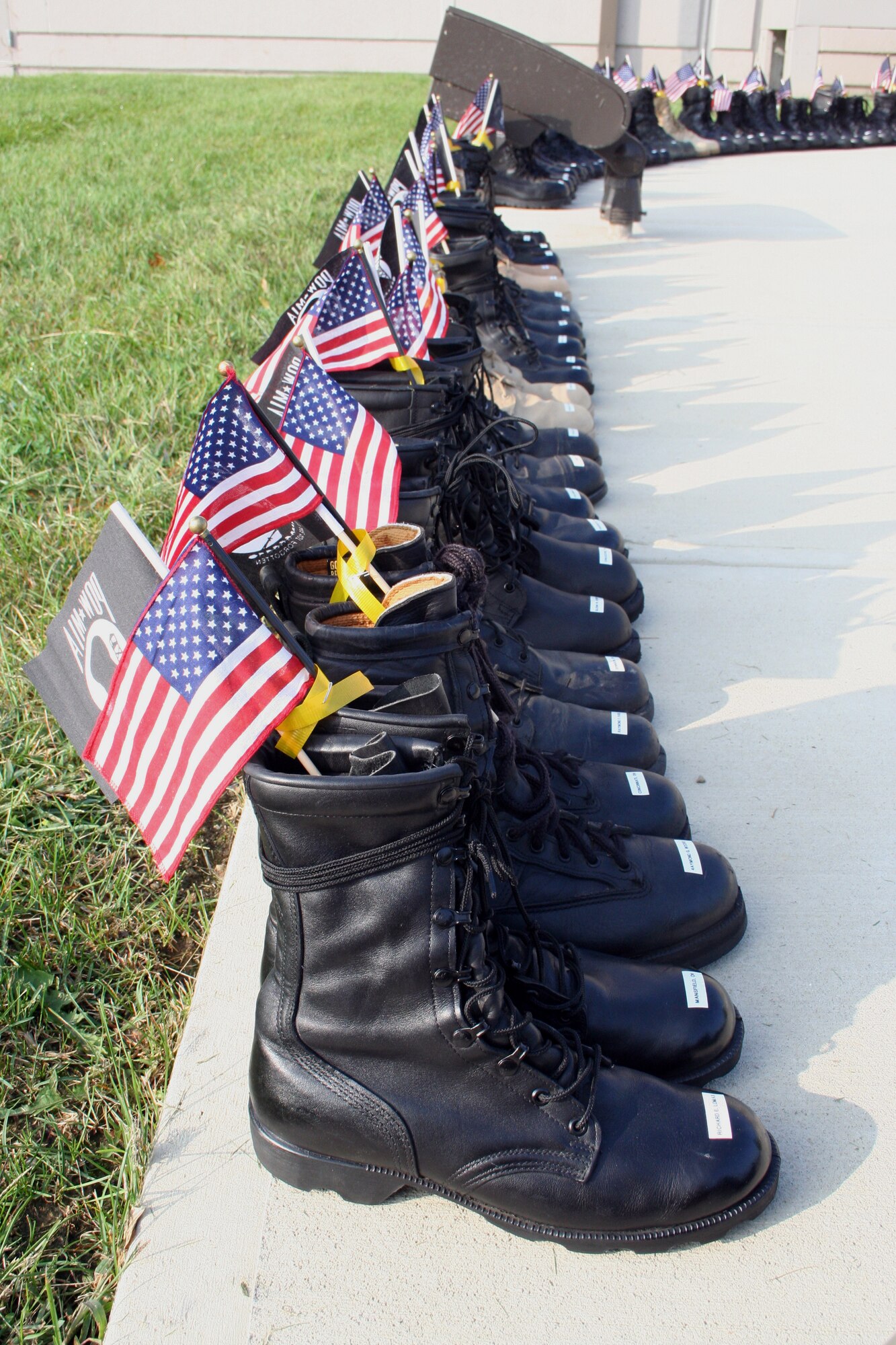 WRIGHT-PATTERSON AFB, Ohio -- Eighty-six pairs of boots surround the semicircle flag pole area at the 445th Airlift Wing headquarters building.  Each pair of boots represents 86 Ohioans still unaccounted for from the Vietnam era.  The 87th pair of desert boots in the middle of the circle represents Pfc. Matt Maupin who is still missing from Operation Iraqi Freedom. 

Each pair identifies the missing Ohioan with their rank and name on the right boot and their hometown on the left boot. Each pair of boots is tied together and is adorned with a small American flag and POW/MIA flag crossed and tied with a small yellow ribbon. (U.S. Air Force Photo/Maj. Ted Theopolos).
