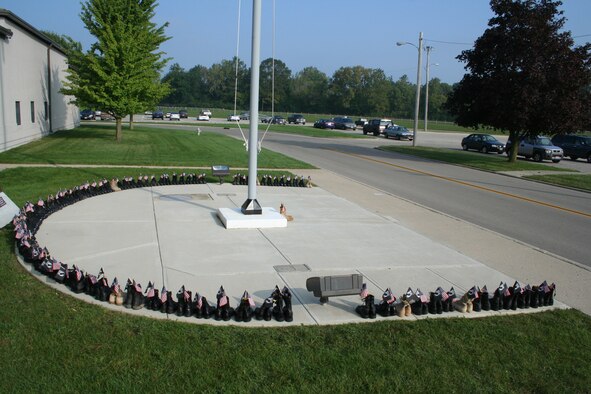 WRIGHT-PATTERSON AFB, Ohio -- Eighty-six pairs of boots surround the semi-circle flag pole area at the Air Force Reserve's 445th Airlift Wing headquarters building.  Each pair of boots represents 86 Ohioans still unaccounted for from the Vietnam era.  The 87th pair of desert boots in the middle of the circle represents Pfc. Matt Maupin who is still missing from Operation Iraqi Freedom. 

On the right boot is his rank and name and on the left is his hometown in Ohio.  Each pair of boots is tied together and is adorned with a small American flag and POW/MIA flag crossed and tied with a small yellow ribbon. (U.S. Air Force photo/Maj. Ted Theopolos).
