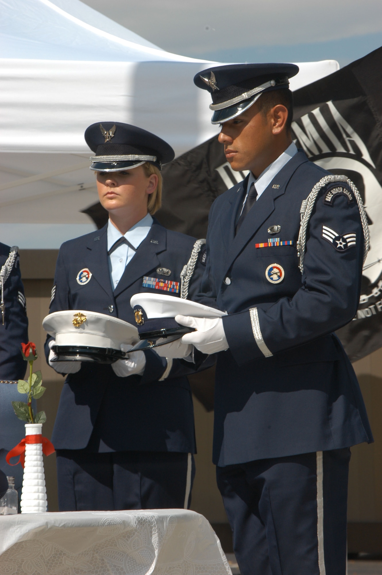 Staff Sgt. Jessica Phelps and Senior Airman Joseph Morales, members of the Air Reserve Personnel Center and Defense Finance and Accounting Service honor guard, wait to place service hats on the POW/MIA table during a Prisoner of War and Missing in Action remembrance ceremony in Denver Sept. 14. (DOD photo/Cheresa D. Theiral)