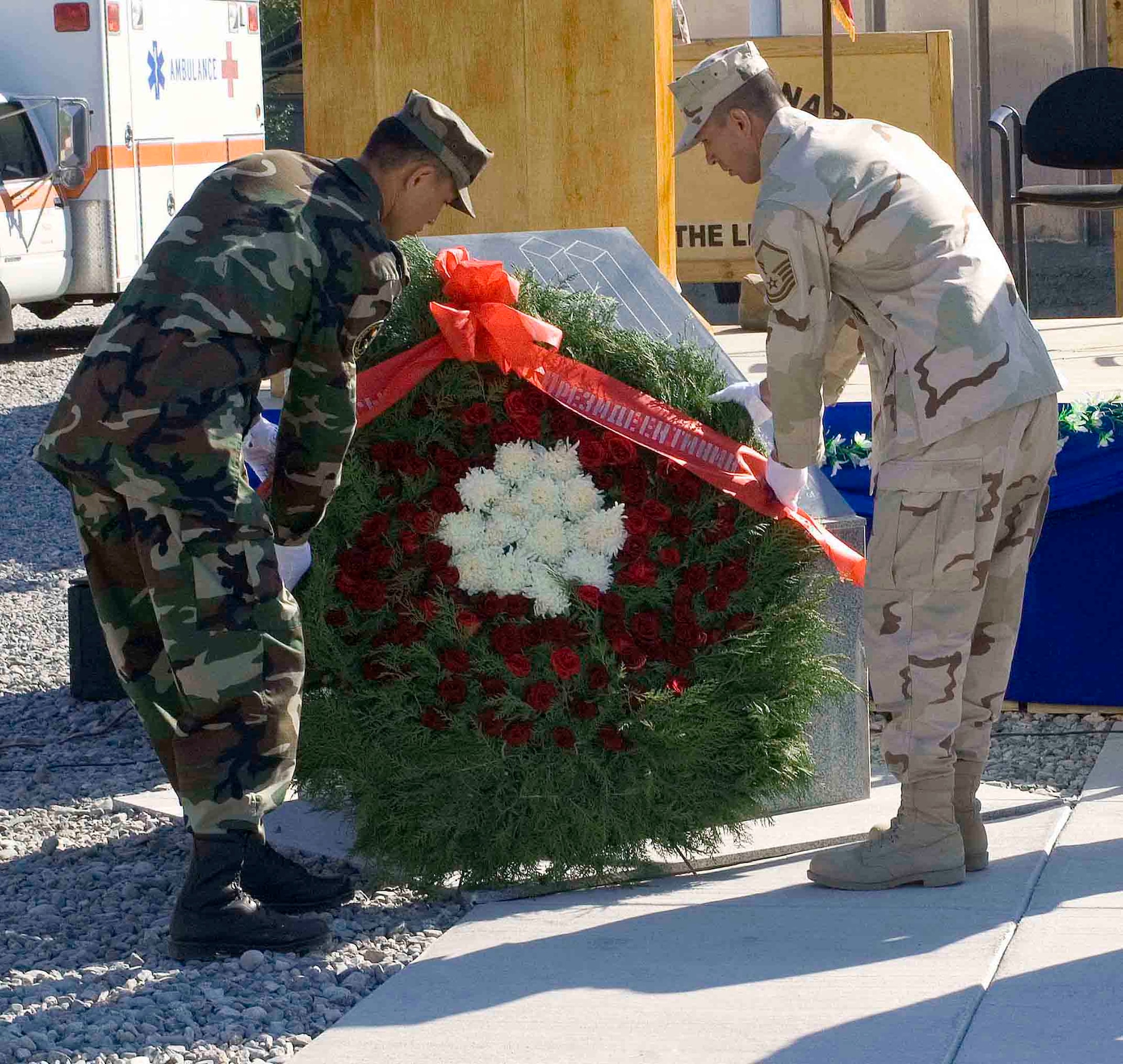 Master Sgt. Tung Nguyen (right), 376th Expeditionary Contracting Squadron, and a member of the Kyrgyz military place a wreath at the base of the Peter J. Ganci memorial during a remembrance ceremony at Manas Air Base, Kyrgyzstan, Sept. 11. (U.S. Air Force photo/Jim Westfall)