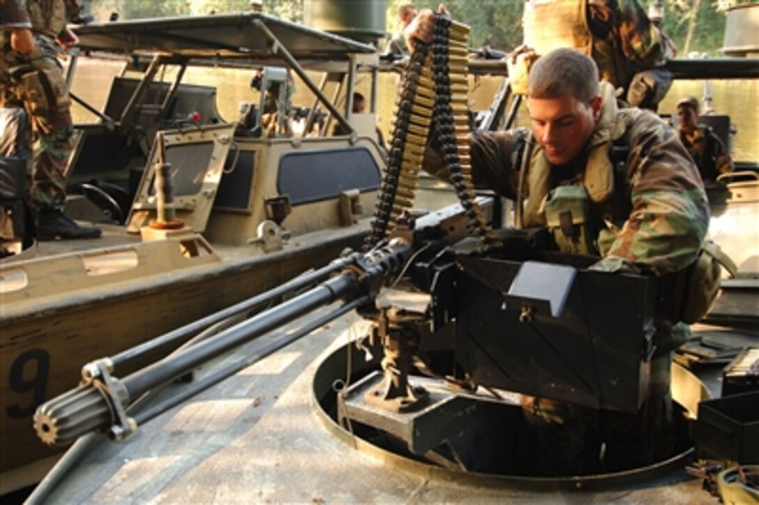 Navy Seaman Apprentice Sean Costello loads a .50-caliber machine gun aboard a riverine assault craft at Camp Lejeune, N.C., on Sept. 8, 2006.  U.S. Navy sailors with Riverine Group One are conducting high-speed, small unit riverine craft training in the Cape Fear River in North Carolina.  