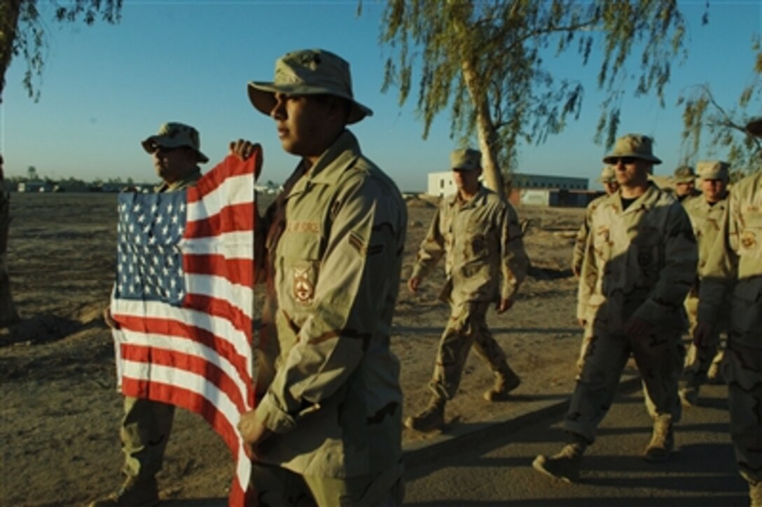 U.S. Air Force Airmen with 332nd Air Expeditionary Wing carry the American flag during the Sept. 11, 2001, remembrance walk on Balad Air Base, Iraq, on Sept. 11, 2006.  