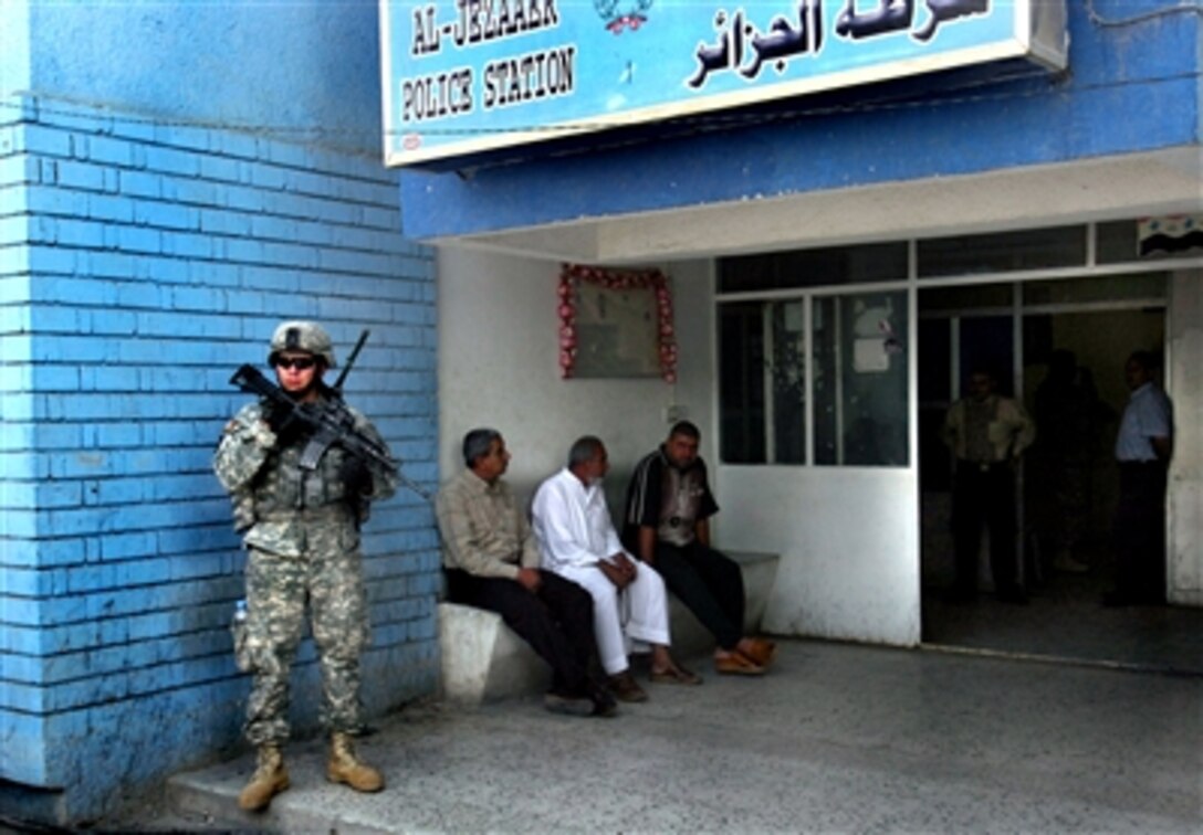 U.S. Army Spc. Anthony D. Johnston, 172nd Stryker Brigade Combat Team, waits outside the Al Jezaaer Police Station as his team coordinates with Iraqi police to conduct a reconnaissance mission in Sadr City, Iraq, Sept. 8, 2006.  