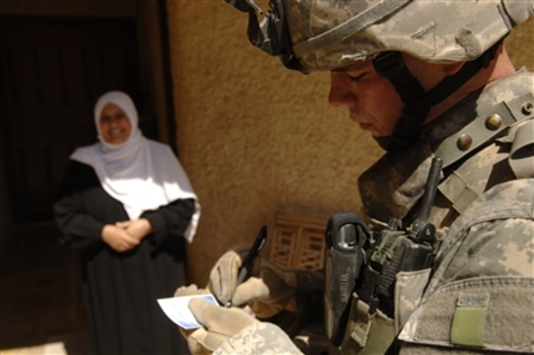 U.S. Army Sgt. Ribbeck fills out a claim form for a local resident during a combined cordon and search mission in Baghdad, Iraq, on Sept. 10, 2006.  Ribbeck is attached to Bravo Company 2nd Battalion, 1st Infantry Regiment.  