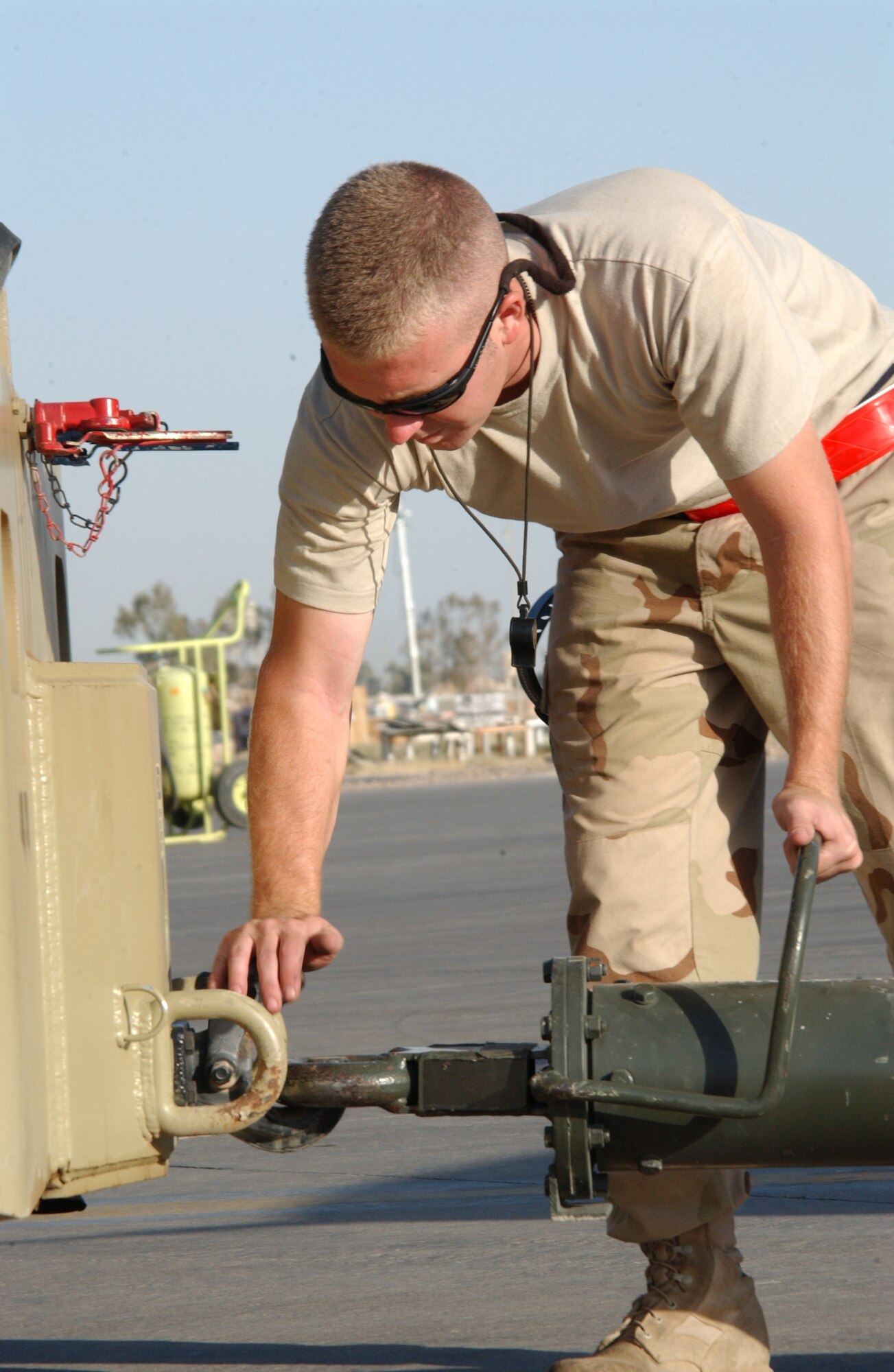 Staff Sgt. Kenny McDonald gets ready to tow an F-16 Fighting Falcon to the tarmac for an engine test at Balad Air Base, Iraq. The sergeant is a crew chief with the 332nd Expeditionary Aircraft Maintenance Squadron's aircraft maintenance unit. (U.S. Air Force photo/SrA Kerry Solan-Johnson)                             