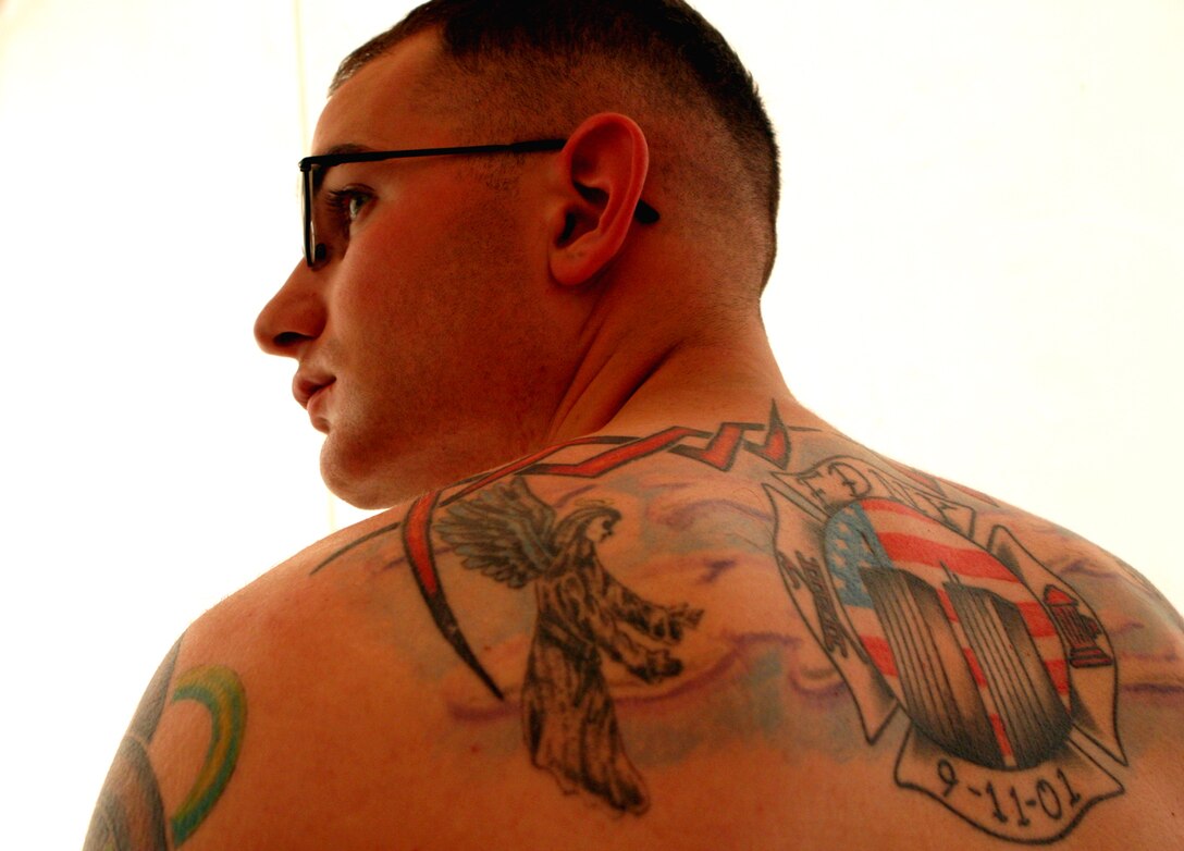 Lance Cpl. Michael Burtnick, a 22-year-old aviation ordnanceman with Marine Medium Helicopter Squadron 365 (Rein.), displays the tattoo that he designed himself as a memorial to New York City firefighters who died on Sept. 11, 2001. Burtnick, along with 19 other Marines and Sailors from the 24th Marine Expeditionary Unit (Special Operations Capable), spent 10 days in September supporting air operations over the skies of Afghanistan as part of Operation Enduring Freedom.