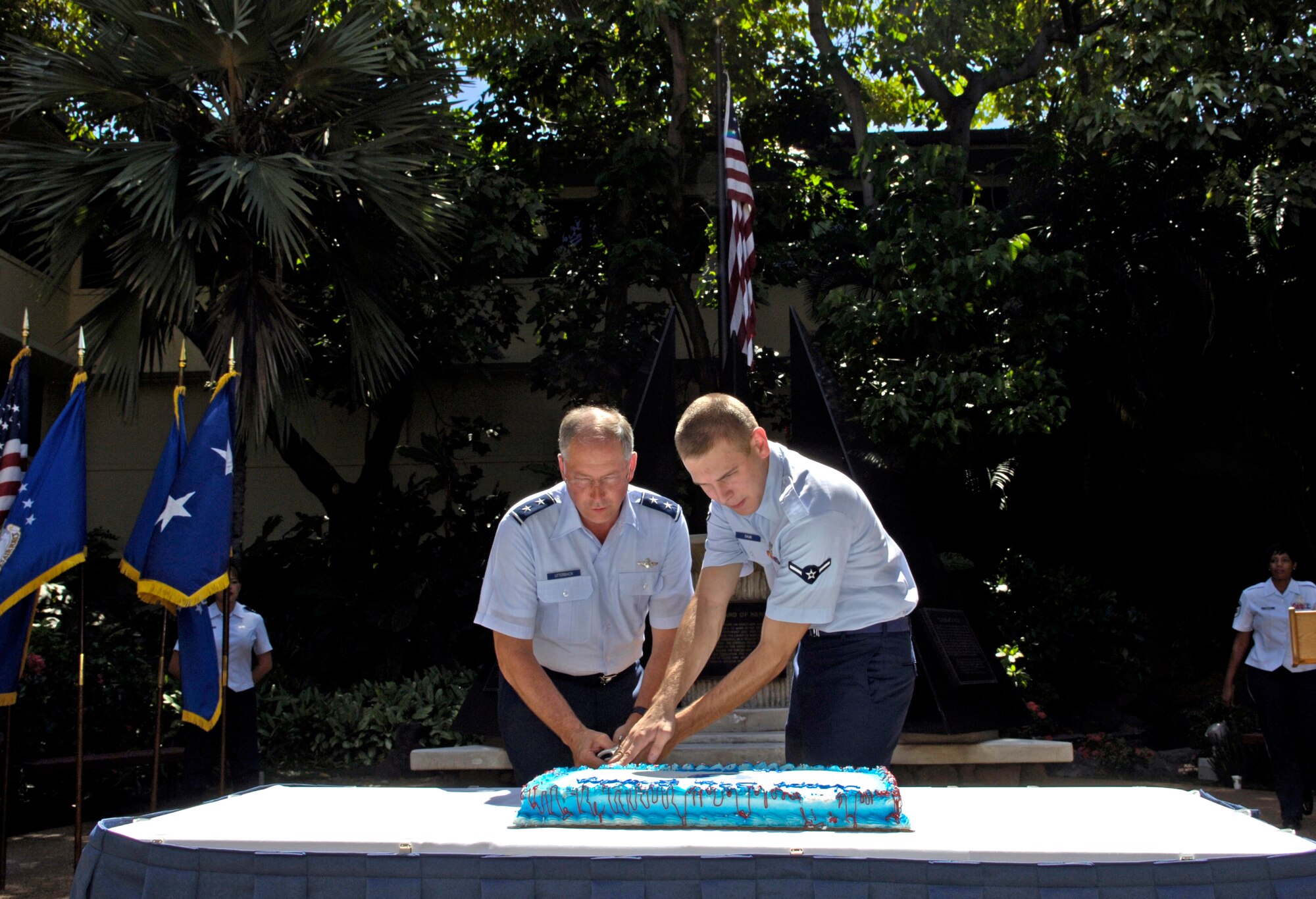 Maj. Gen Chip Utterback Pacific Air Forces deputy commander and Airman Matthew Saum cut an Air Force birthday cake in the Courtyard of Heroes on Hickam Air Force Base Hawaii Sept. 18. Airman Saum is the lowest ranking Airman in the PACAF headquarters and Gen. Utterback was most senior at the event. (U.S. Air Force photo/ Tech. Sgt. Shane A. Cuomo)