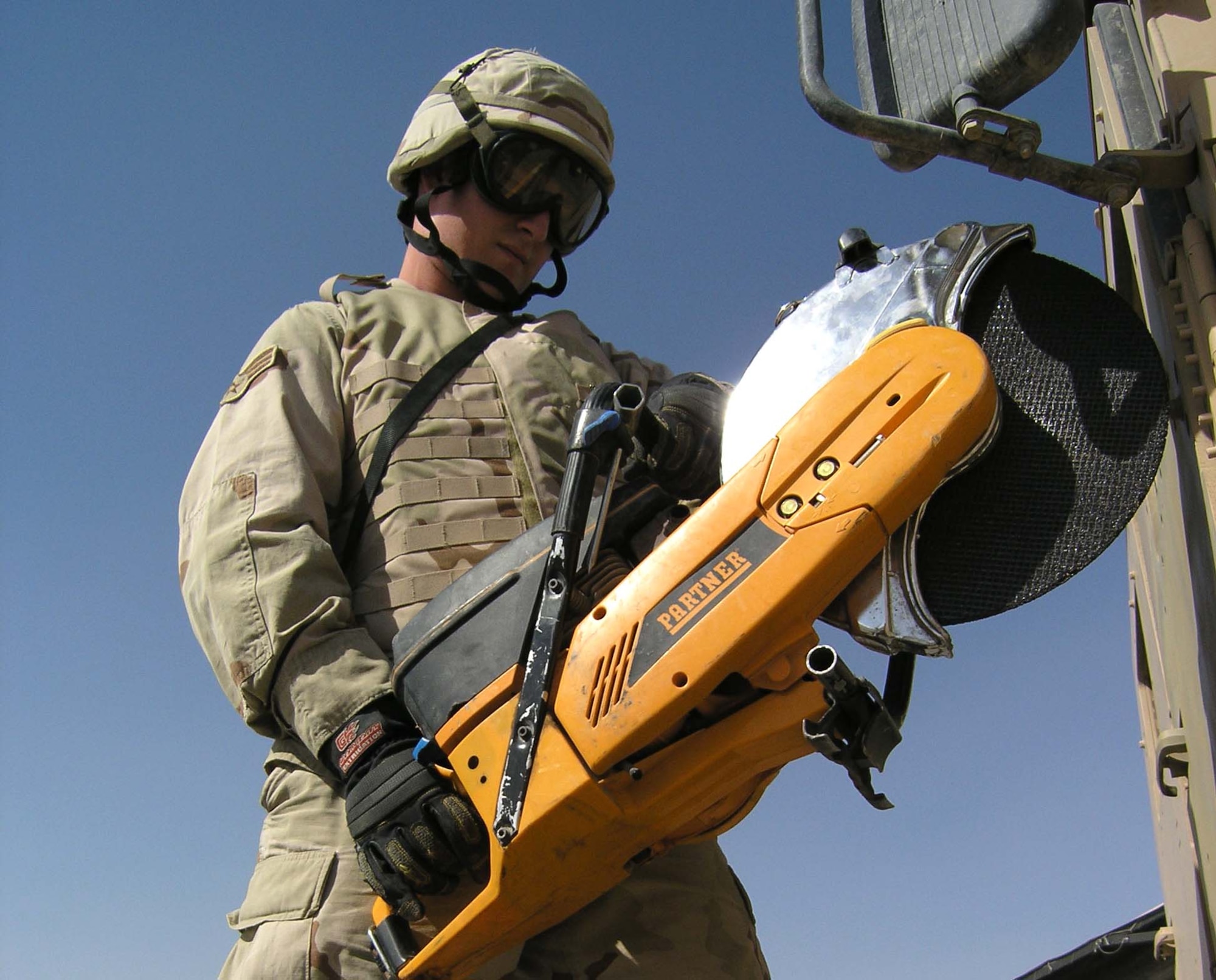 Senior Airman Jurle Gaver prepares to cut the door off a Humvee using a K-12 partner saw Sept. 18. The saw is used to help extract victims trapped inside a vehicle. Airmen Gaver is assigned to the 407th Civil Engineer Squadron?s Fire Protection Flight at Ali Base, Iraq. (U.S. Air Force Photo/TSgt. Ryan Mattox)
      