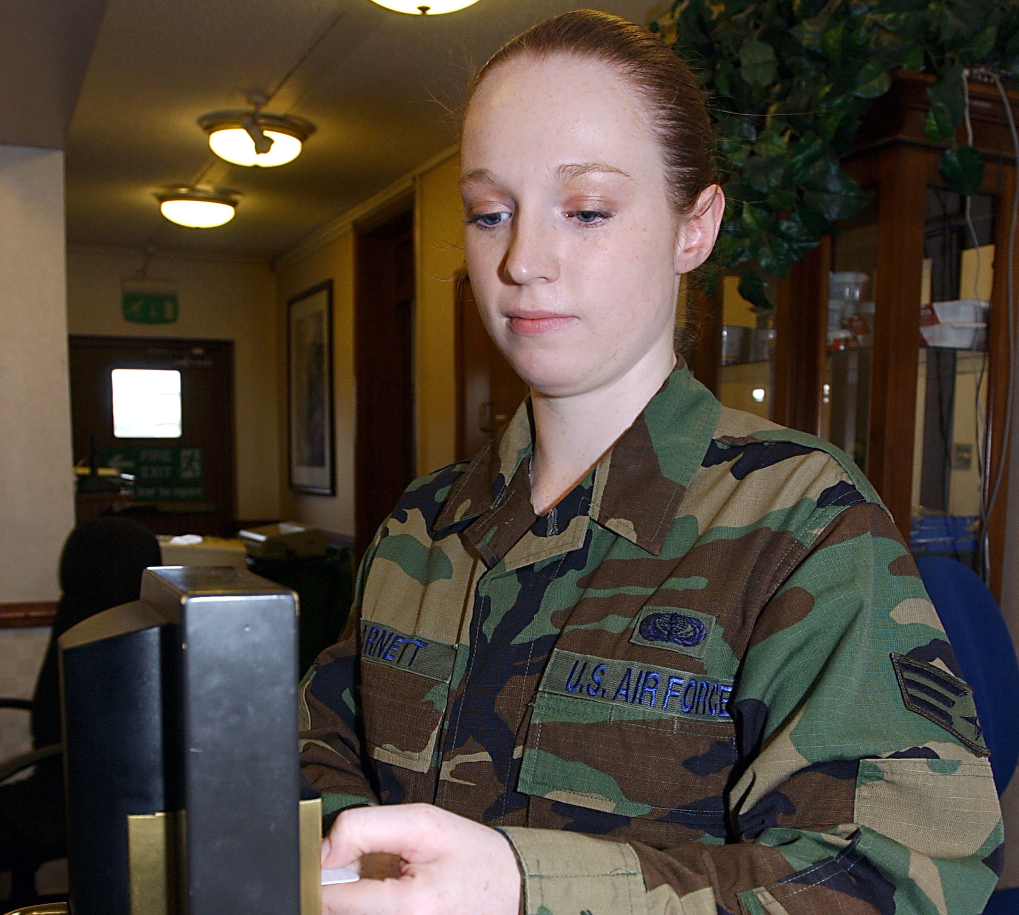 Senior Airman Abbragail Barnett tests a room key card in a fully working door handle device kept at the front counter of the Royal Air Force Lakenheath billeting office. Airman Barnett is a 48th Services Squadron desk clerk. (U.S. Air Force photo)