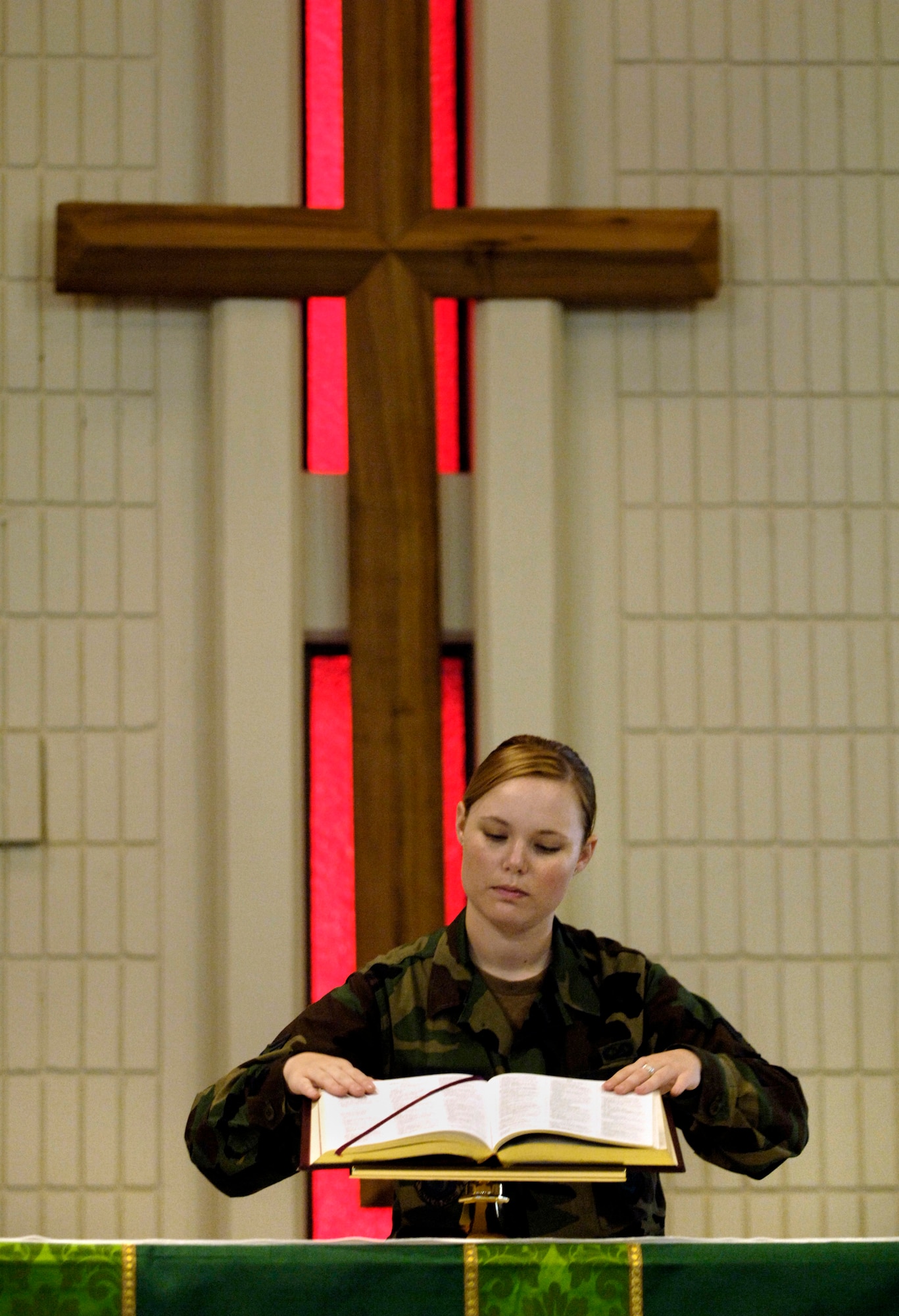 Senior Airman Melissa Harrington places a Bible on the altar of the base chapel at Hickam Air Force Base, Hawaii, Sept. 18. Airman Harrington is a chaplain's assistant for the 15th Airlift Wing. (U.S. Air Force photo/Tech. Sgt. Shane A. Cuomo)
