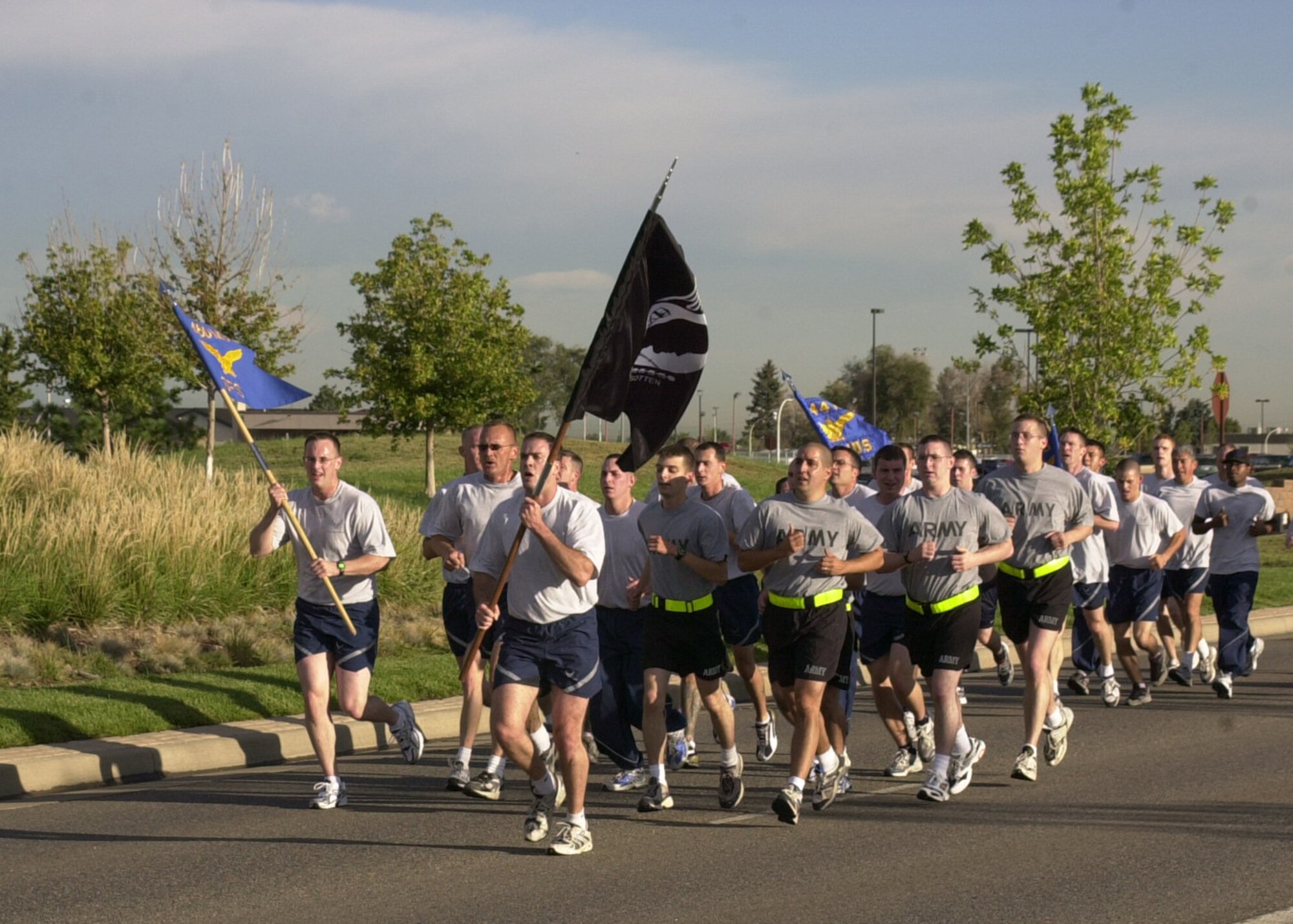 BUCKLEY AIR FORCE BASE, Colo. -- Airmen and Soldiers run with the POW/MIA flag during Team Buckley's Memorial Run Sept. 15. to pay tribute on National POW/MIA Recognition Day. Members from all services took part in the run as well as a POW/MIA vigil. The vigil concisted of four-person teams standing posts for 15 minutes throughout the day around the flag poles in front of the 460th Space Wing headquarters building here. (U.S. Air Force photo by Airman 1st Class Michelle Cross)                     