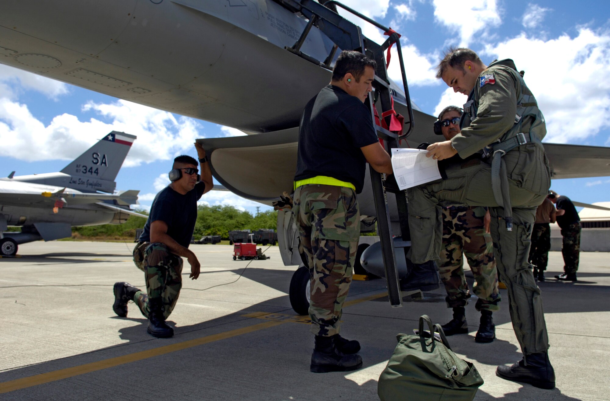 Maj. Ryan Jones and a maintenance crew look over a maintenance log after returning from an air-to-air mission to Hickam Air Force Base, Hawaii, Sept. 8 during Exercise Sentry Aloha. The Airmen are from the Texas Air National Guard's 149th Fighter Wing. (U.S. Air Force photo/Tech. Sgt. Shane A. Cuomo) 