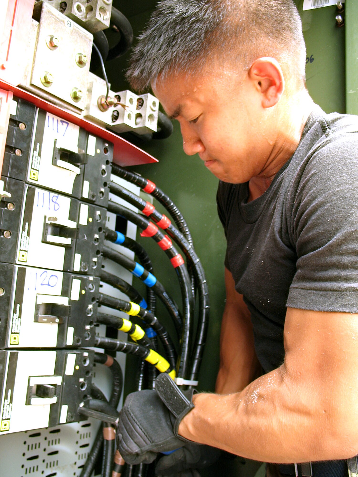 Airman 1st Class Alex Jaime wrestles an electrical cable into place in a transformer on Wake Island Sept. 17. Airman Jaime is a member of the damage assessment team deployed to the atoll from Hickam Air Force Base, Hawaii, to estimate the cost of damage left by Super Typhoon Ioke. He is assigned to the 15th Civil Engineer Squadron. (U.S. Air Force photo/Tech. Sgt. Chris Vadnais)
