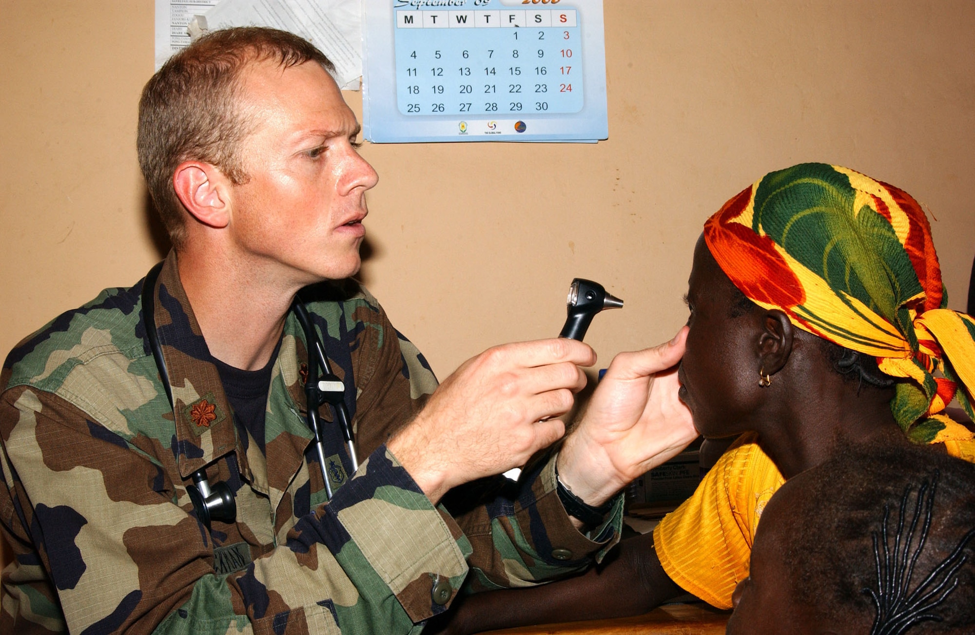 Maj. Shane Dieckman, a family care physician from the 52nd Medical Group, Spangdahlem, AB, Germany, does an inital exam on a patient at the Tampiong Clinic in Tamale, Ghana, during Med Flag 2006.  Major Dieckman is one of more than 50 U.S. Air Forces in Europe medical, support and security personel deployed to the West African city for the 10-day exercise.  USAFE personnel are working with their African military counterparts by staging medical operations in the countries of Benin, Senegal, Nigeria, and Ghana.   The Tamale mission includes medical field clinics in the remote city of Tampiong, and one at the edge of Tamale, where local residents can see an optometrist, dentist, pediatrician or family care physician.  (Photo by TSgt Pamela Anderson)
