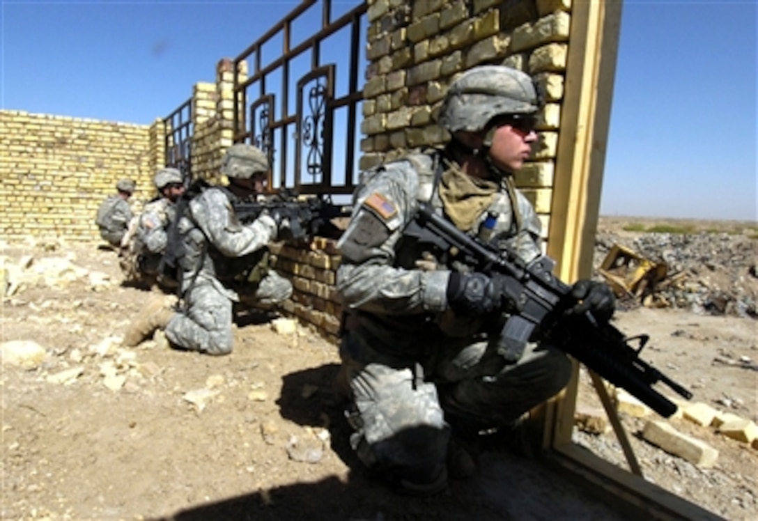 U.S. Army soldiers from Bravo Company, 1st Battalion, 17th Infantry Regiment, 172nd Stryker Brigade Combat Team, scan an open field before crossing it during a cordon and search mission in Ur, Iraq, Sept. 14, 2006.  