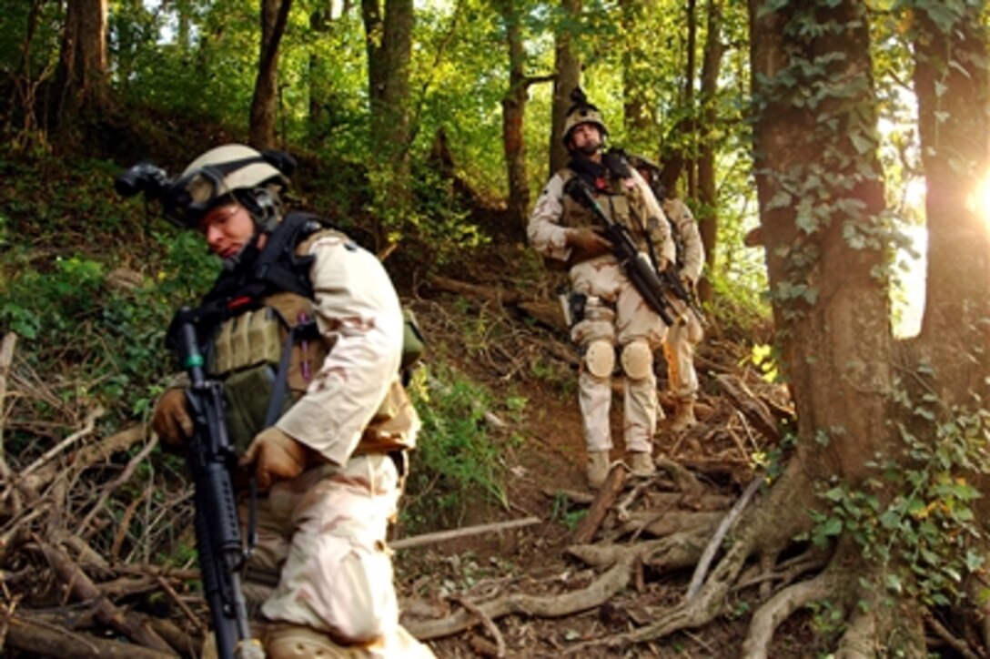 U.S. Navy sailors with Riverine Squadron 1 walk down a trail to board riverine assault crafts to conduct an exercise mission at Camp Lejeune, N.C., Sept. 8, 2006. RIVRON-1 is assigned to Navy Expeditionary Combat Command.